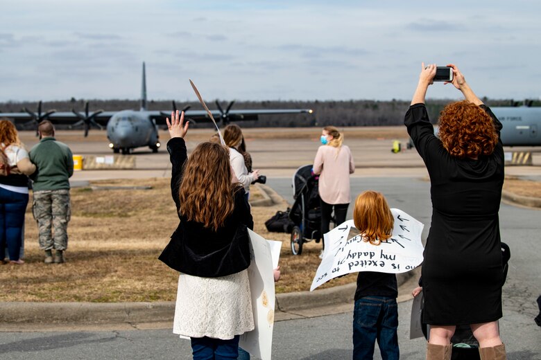 Family members wave at an aircraft