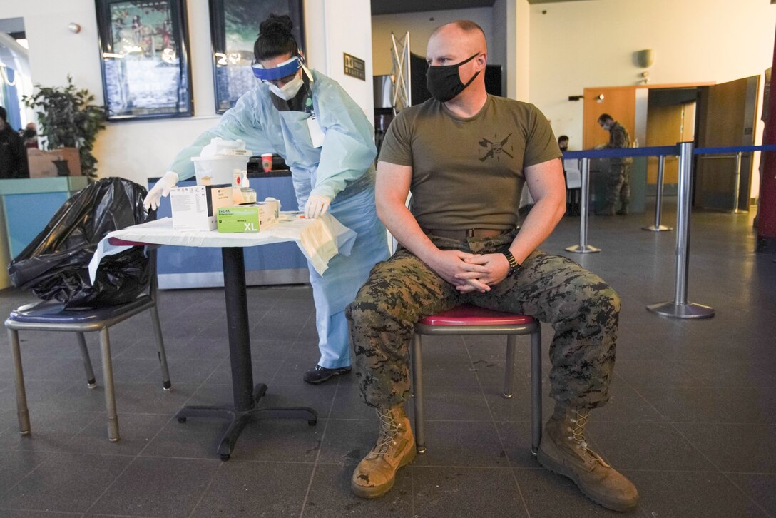 U.S. Marine Corps Sgt. Maj. Aaron G. McDonald, the sergeant major of U.S. Marine Corps Forces Europe and Africa, prepares to receive the mRNA-1273 COVID-19 vaccine at U.S. Army Garrison Patch Barracks, near Stuttgart, Germany, Jan. 26, 2021. The voluntary vaccines are being administered in a phased approach, prioritizing health care workers and first responders, as well as mission critical and deploying personnel. Marines will continue to practice safety protocols to diminish the risk of COVID-19. (U.S. Marine Corps photo by Cpl. Claudia Nix)