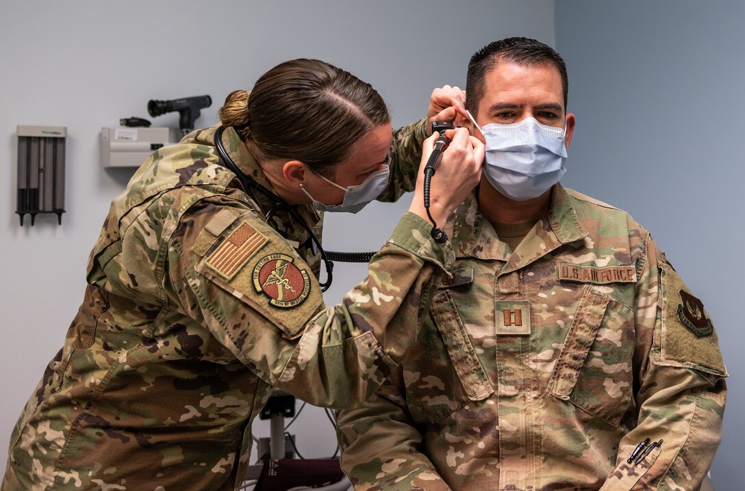 military medical physician inspect another member's ear