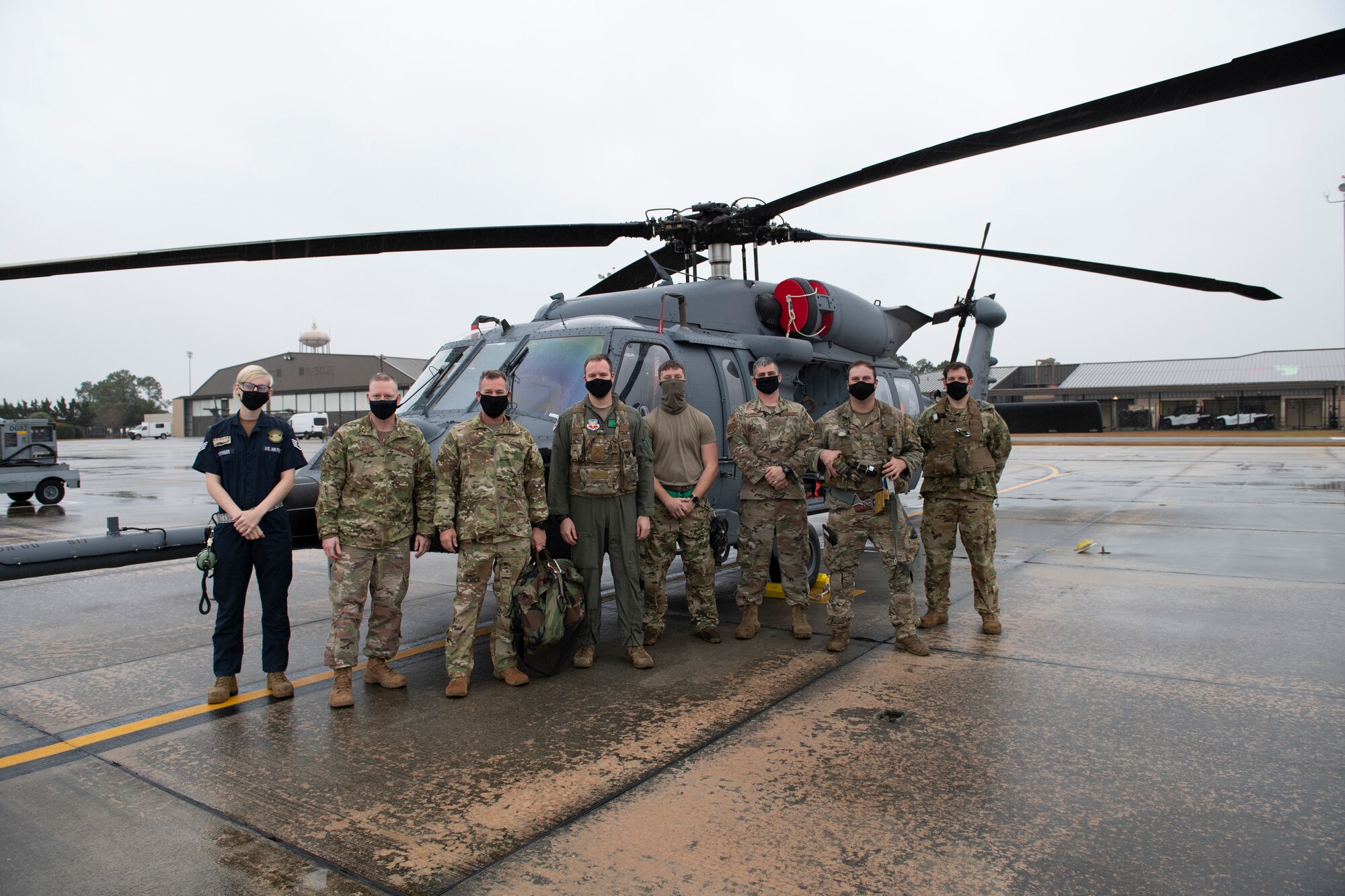 A photo of Major General posing with Airmen assigned to the 41st Rescue Squadron in front of the new HH-60W Jolly Green II helicopter.