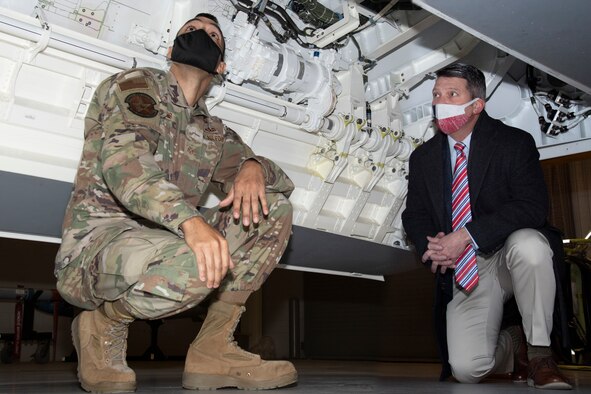 Staff Sgt. Christopher Lewis and Rep. Ronny Jackson look at an F-22 aircraft maintenance trainer