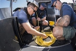 Petty Officer 1st Class Brian Korte, Petty Officer 2nd Class Adam Harris and Petty Officer 2nd Class Garett Brada, Coast Guard divers attached to Regional Dive Locker West in San Diego, prepare a remotely operated vehicle to scan piers near the port of San Francisco in preparation for Fleet Week Tuesday, Oct. 6, 2015.