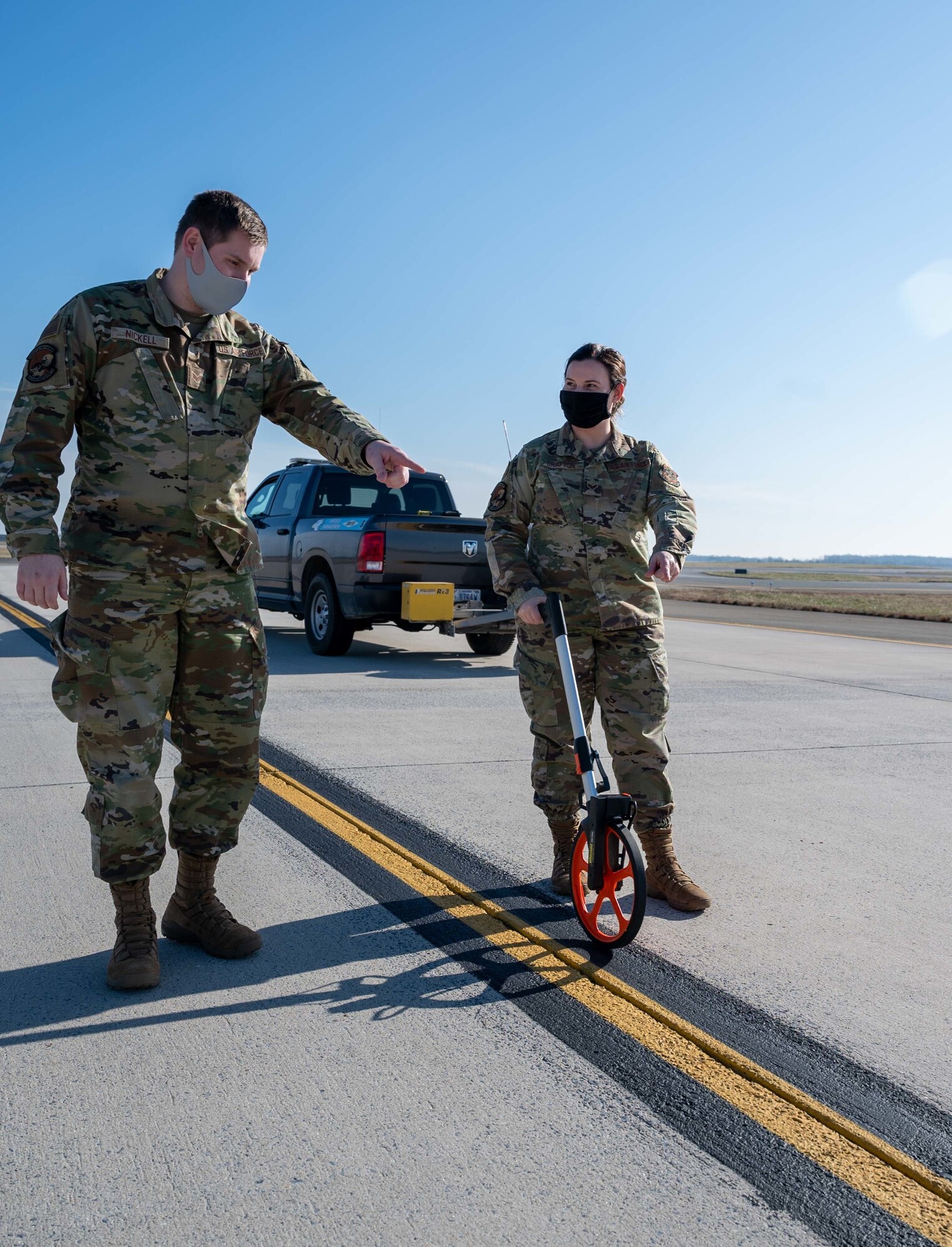Senior Airman Kristina Grafton, 436th Operation Support Squadron airfield management operations supervisor and Senior Airman Keyton Nickell, 436th Airfield Operation Support Squadron airfield management shift lead, measure a center taxi line on the runway at Dover Air Force Base, Delaware, Jan. 14, 2021. As airfield management journeymen, Grafton and Nickell manage airfield operations, coordinate with civil engineers, safety, air traffic control and various other base agencies to ensure safe aircraft operations within the airfield of Dover AFB. (U.S. Air Force photo by Airman 1st Class Faith Schaefer)