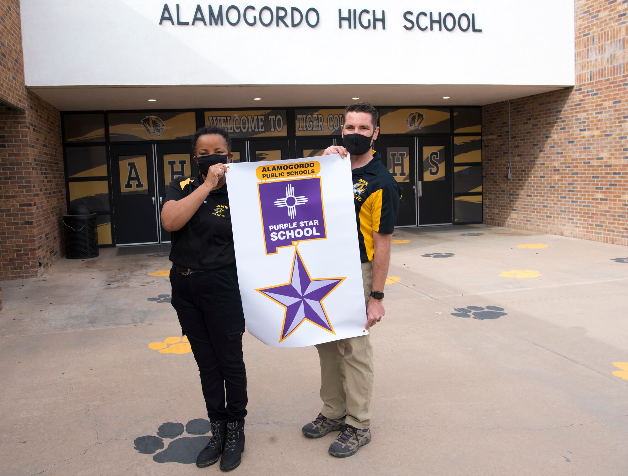Master Sgt. Hope Sanders, and Maj. Tom Odgers, Alamogordo High School JROTC leaders, pose with Purple Star School poster for a photo, Jan. 19, 2021 at Alamogordo, New Mexico. The Junior Reserve Officers’ Training Corps is a federal program sponsored by the United States Armed Forces in high schools across the United States and United States military bases. (U.S. Air Force photo by Airman 1st Class Jessica Sanchez)