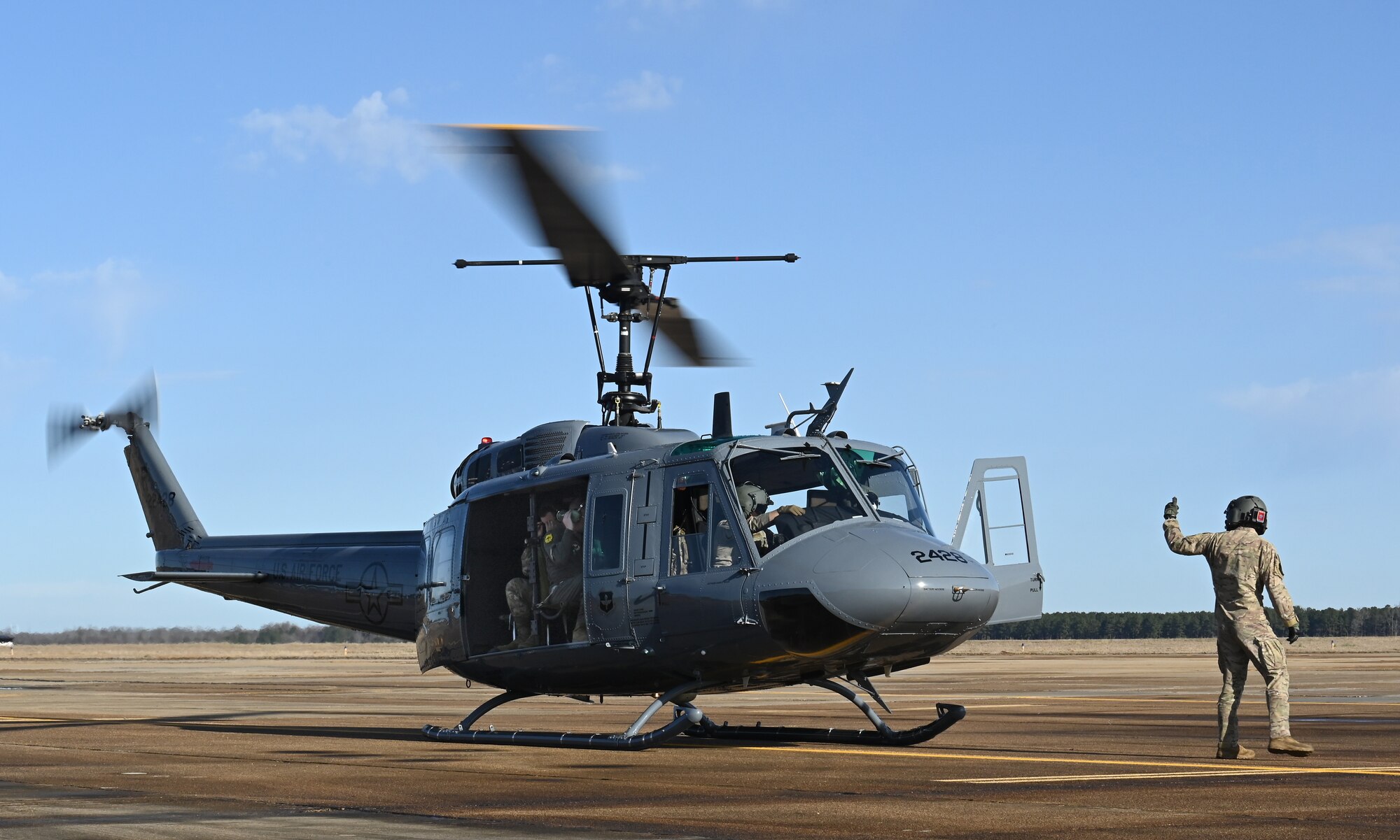 U.S. Air Force Tech. Sgt. Hayden Reynolds, 23rd Flying Training Squadron instructor flight engineer, signals the pilots for take-off for an aircraft familiarization flight on Columbus Air Force Base, Miss., Jan. 26, 2021. Since January, 1994, the 23d FTS is the United States Air Force's primary source of helicopter pilots for special operations, combat search and rescue, missile support, and distinguished visitor airlift missions.  (U.S. Air Force photo by Airman 1st Class Jessica Haynie)