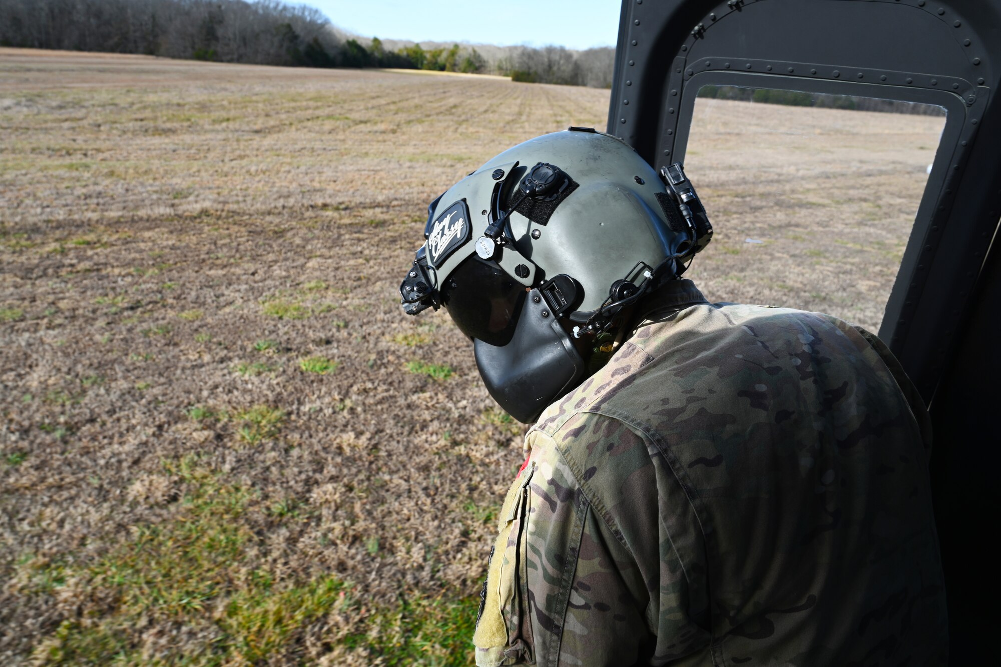 U.S. Air Force Tech. Sgt. Hayden Reynolds, 23rd Flying Training Squadron instructor flight engineer, checks the ground before landing a TH-1H Huey Jan. 26, 2021, in Columbus, Miss. The Vietnam-era UH-1H helicopters were converted into brand new TH-1H helicopters. (U.S. Air Force photo by Senior Airman Jake Jacobsen)