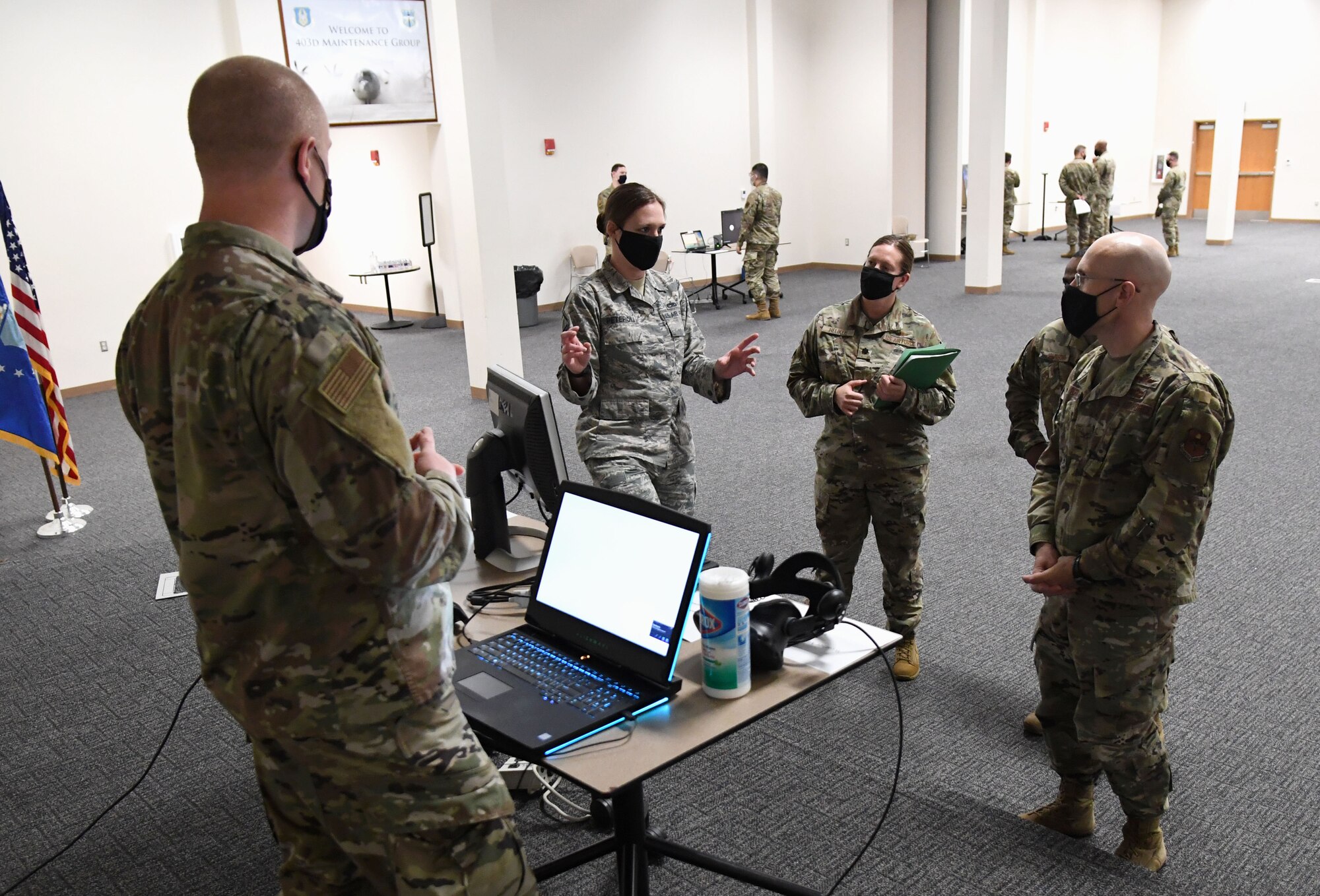 U.S. Air Force Master Sgt. Carolann Peteroli, 335th Training Squadron curriculum developer, explains the capabilities of the weather course virtual reality lab to Col. Chance Geray, 81st Training Group commander, during the 81st TRG Mock Tech Expo inside the Roberts Consolidated Aircraft Maintenance Facility at Keesler Air Force Base, Mississippi, Jan. 27, 2021. The 81st TRG level event was designed to prepare Keesler's nine innovation projects for the Air Education and Training Command level exposition. (U.S. Air Force photo by Kemberly Groue)