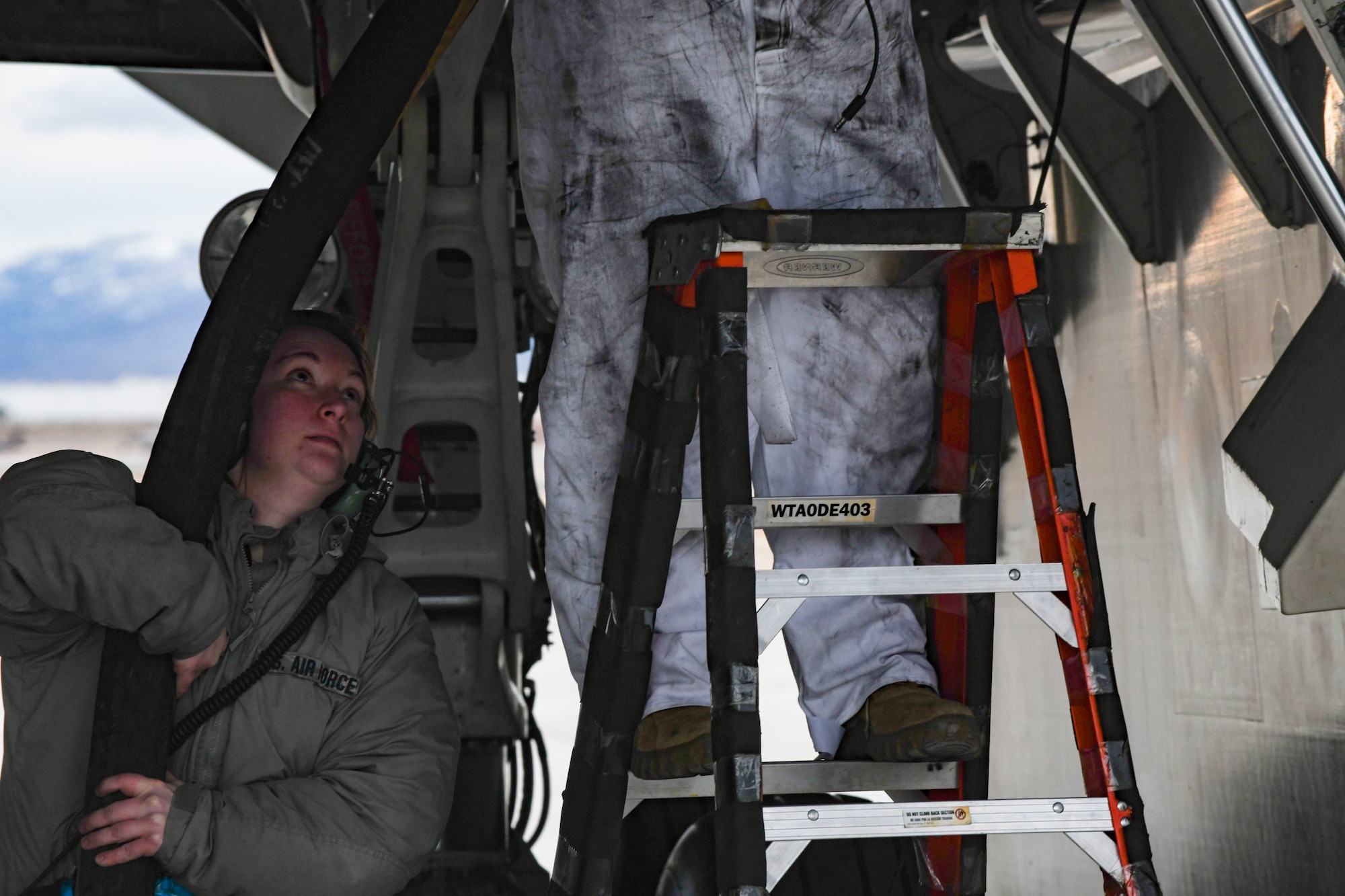 U.S. Air Force Senior Airman Haylee Lund, 393rd Expeditionary Bomb Squadron crew chief, assist securing a fuel line to a B-2 Spirit Stealth Bomber during Red Flag 21-1 at Nellis Air Force Base, Nevada, Jan. 26, 2021. This large force exercise demonstrates the credibility of U.S. and partner forces to address a global security environment and ensure Team Whiteman is able to honor its security commitments. (U.S. Air Force photo by Staff Sgt. Sadie Colbert)