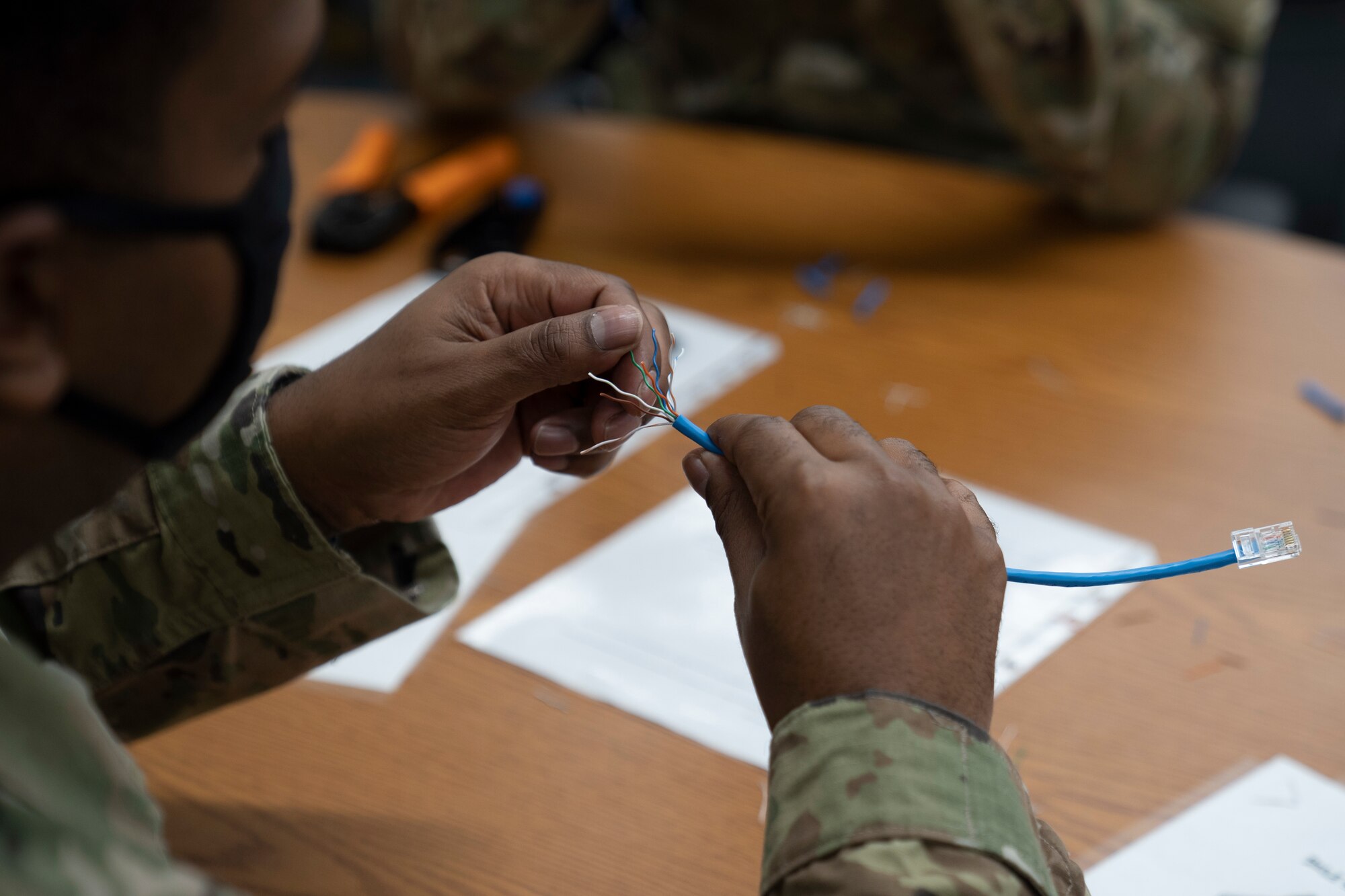 U.S. Air Force Tech. Sgt. Jermaine Miles, 338th Training Squadron instructor, demonstrates how to make an ethernet cable in Bryan Hall at Keesler Air Force Base, Mississippi, on Jan. 26, 2021. The 338th TRS has been working towards a modular curriculum, which enables students to receive the training tailored to their future assignment, for approximately five years. (U.S. Air Force photo by Airman 1st Class Kimberly L. Mueller)