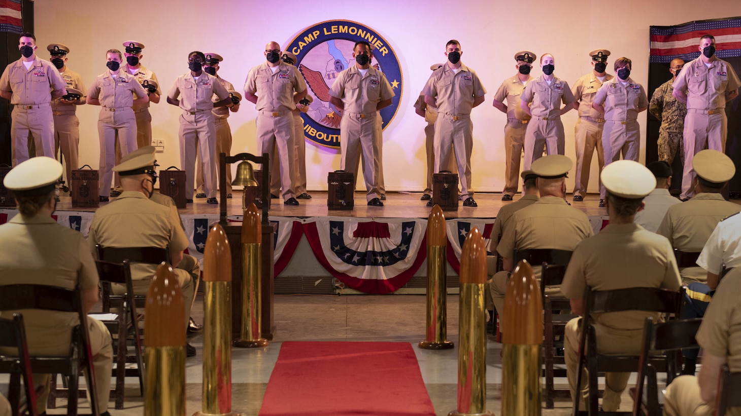 CAMP LEMONNIER, Djibouti – U.S. Navy Chief Selects stand at parade rest in front of their sponsors as they wait to receive their combination cap and be pinned to the rank of Chief in Camp Lemonnier’s Chief’s Pinning and Advancement ceremony, Jan. 24, 2021. The traditional ceremony recognizes the most significant promotion of a Navy Sailor’s career. Camp Lemonnier is an operational installation that enables U.S., allied and partner nation forces to be where and when they are needed to ensure security in Europe, Africa and Southwest Asia. (U.S. Navy photo by Mass Communication Specialist 1st Class Natalia Murillo)