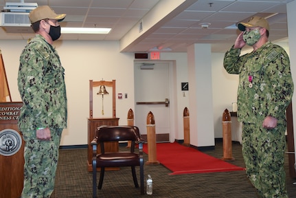 Capt. Daniel S. Layton salutes Capt. Matthew J. Jackson as he assumes command of the Expeditionary Combat Readiness Center (ECRC).