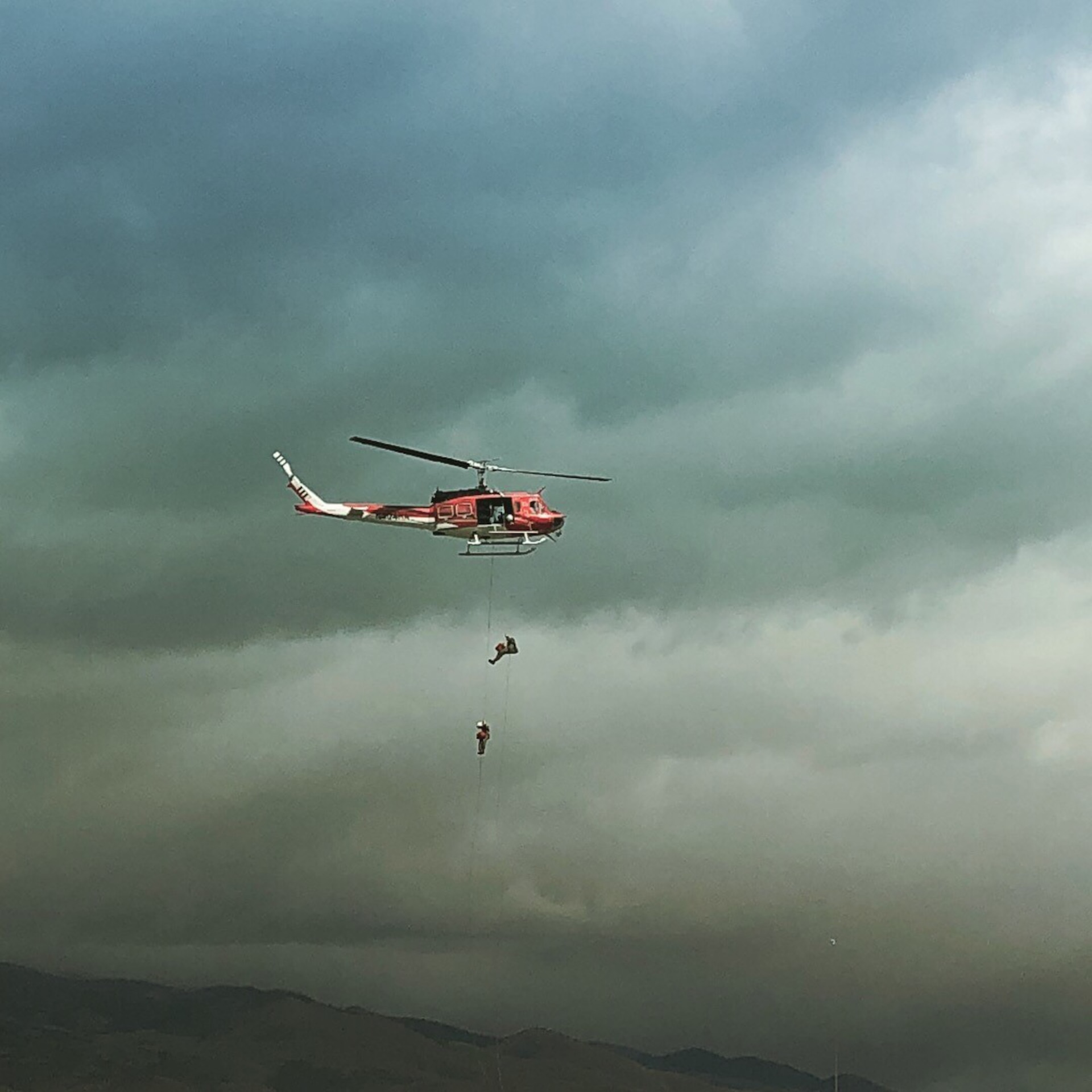 Helicopter rappellers train over a mountain