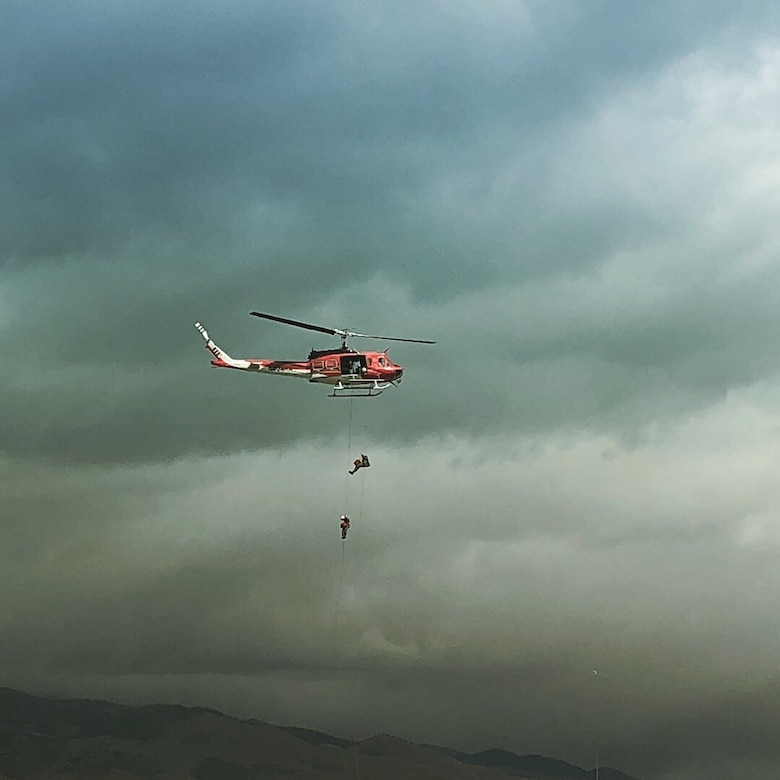 Helicopter rappellers train over a mountain