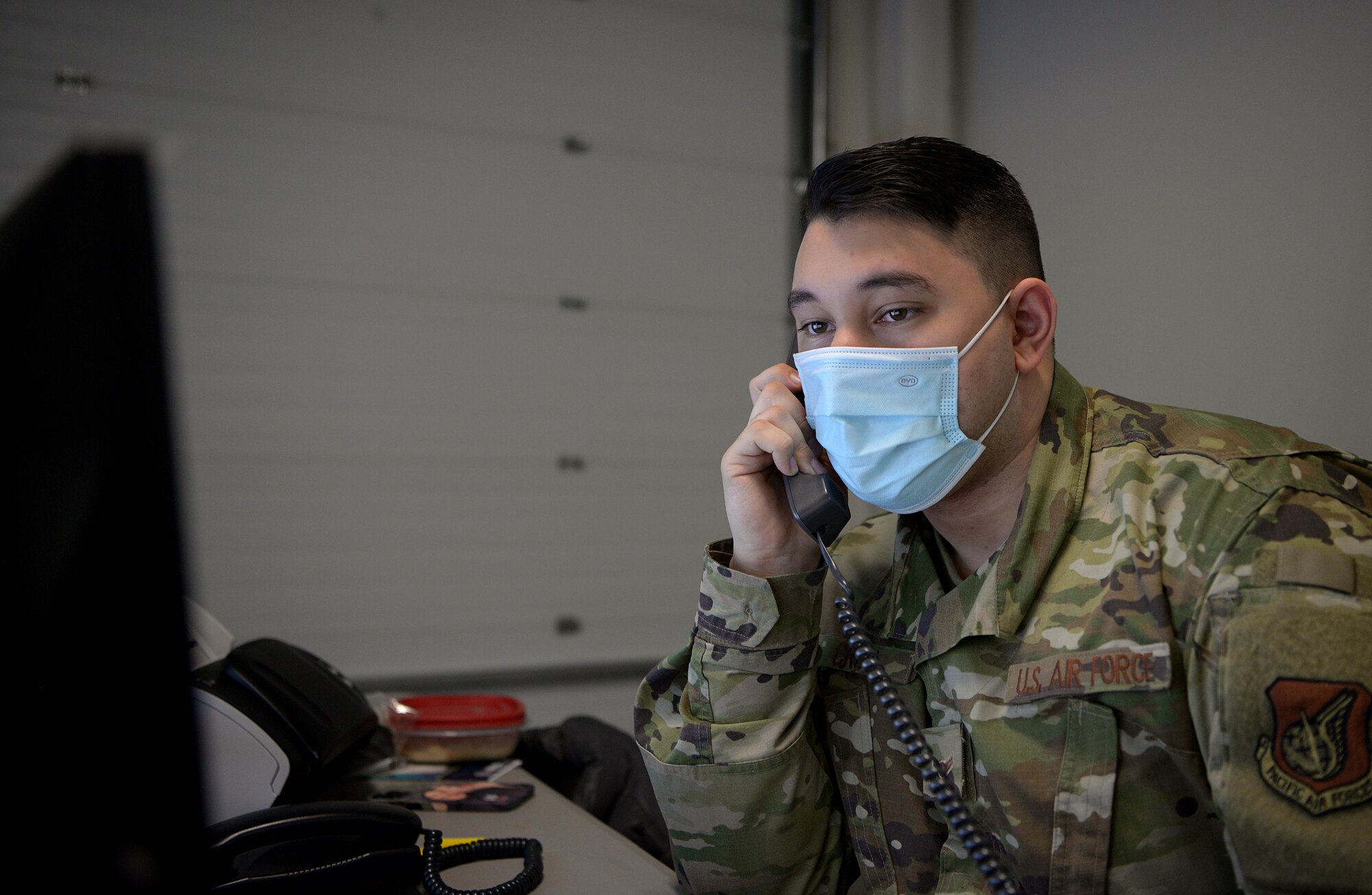 U.S. Air Force Airman 1st Class Giovanni Cruz, 354th Healthcare Operations Squadron health service management specialist, answers a phone call from a patient Jan. 13, 2021 on Eielson Air Force Base, Alaska.. Cruz records COVID-19 tests, logs them into the patient's medical history and works with the 354th Operational Medical Readiness Squadron Public Health Flight to mitigate the spread of the virus. (U.S. Air Force photo by Senior Airman Beaux Hebert)