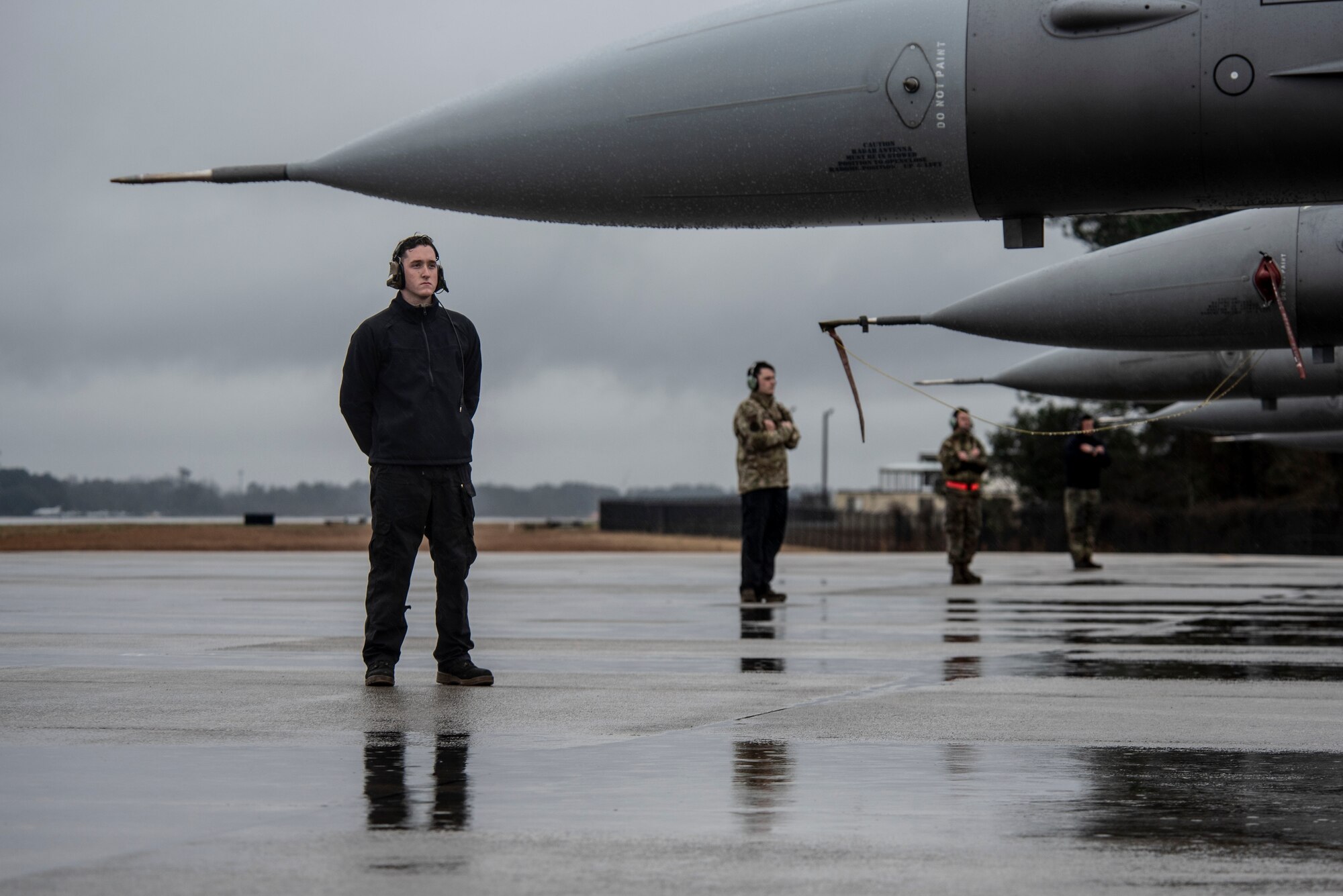 Image of crew chiefs waiting in front of their F-16 Vipers.