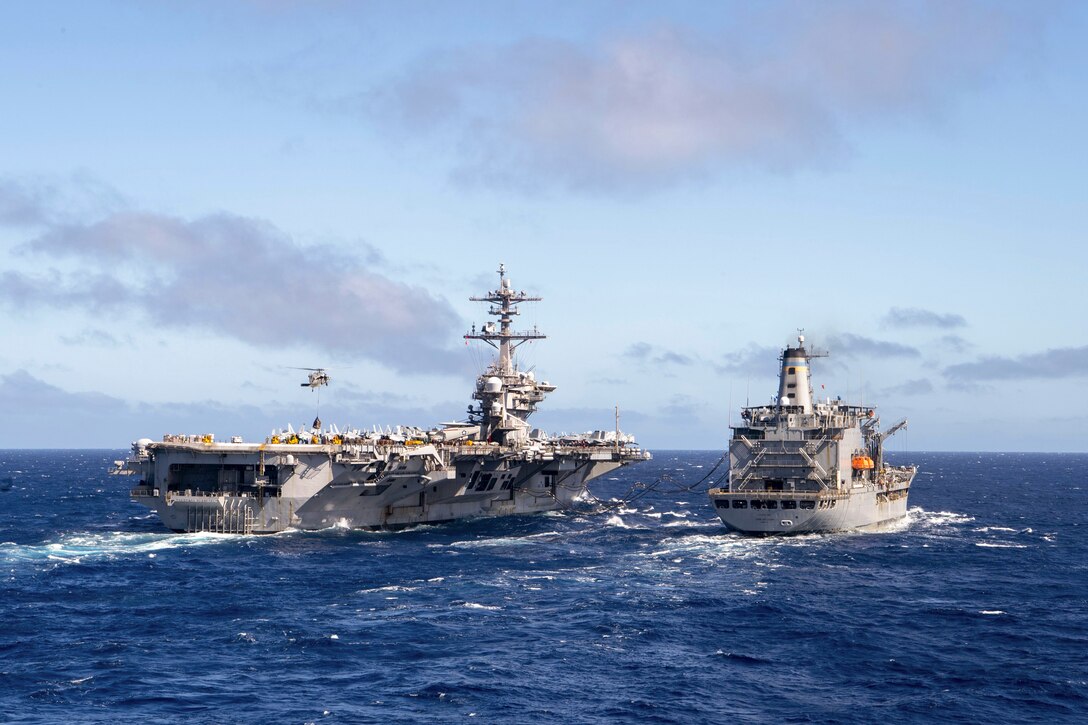 A ship receives fuel and supplies from another ship at sea.