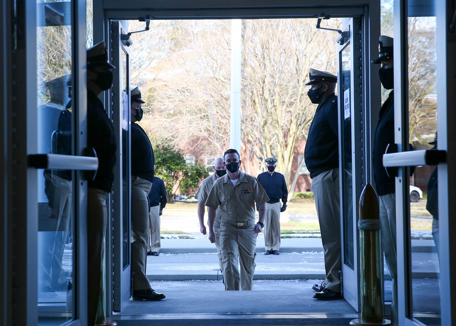 Chief Aviation Aerographer’s Mate Travis Strait, front, and Chief Intelligence Specialist Joshua Waldrop, rear, assigned to U.S. Fleet Forces Command (USFFC), enter the USFFC headquarters in Norfolk, Virginia, in preparation for their advancement during a chief petty officer (CPO) pinning ceremony.