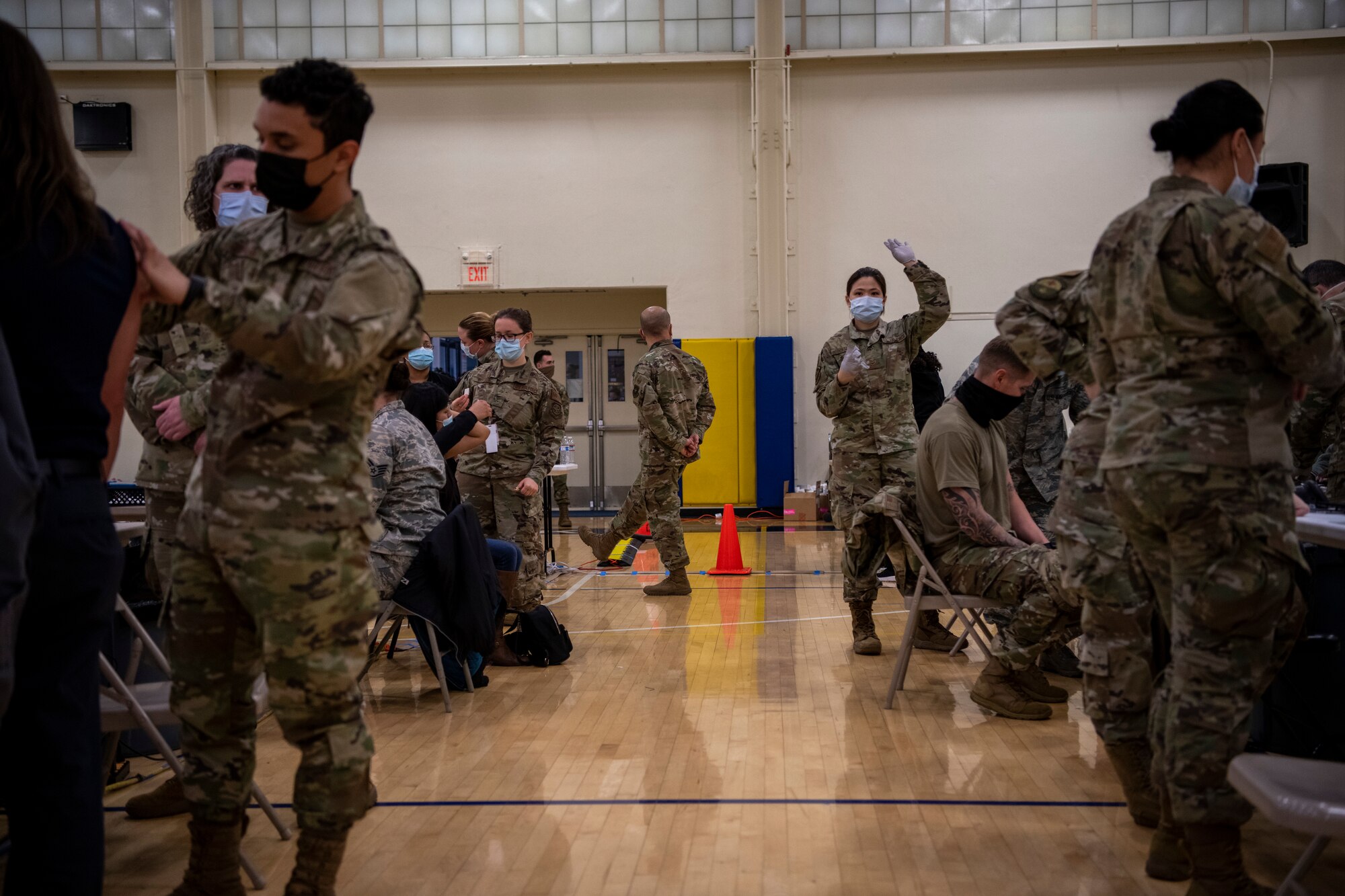 Airmen are standing on each side of the frame while a woman and the end of the isle is waving her hand in the air.