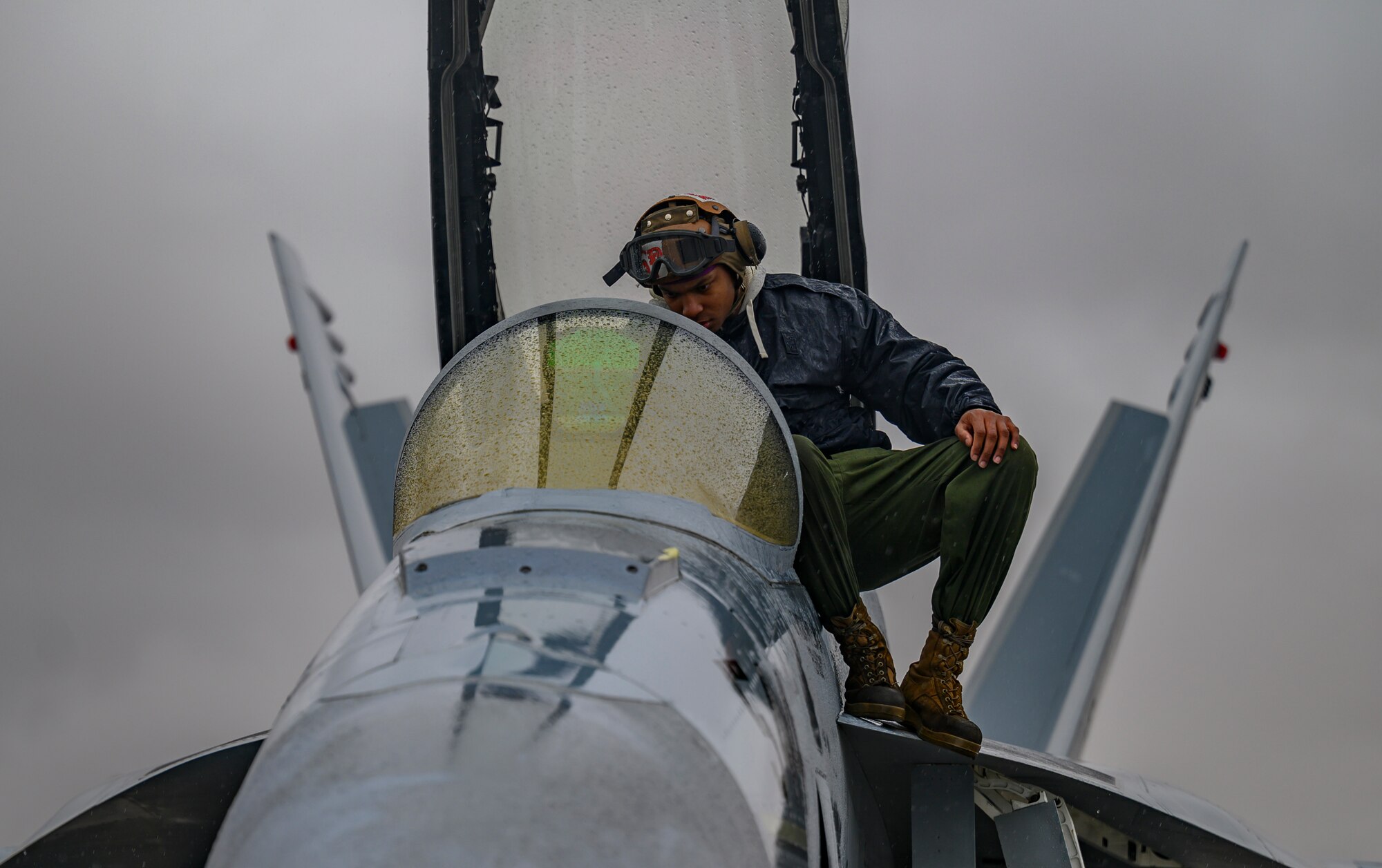 U.S. Navy Airman works on aircraft.