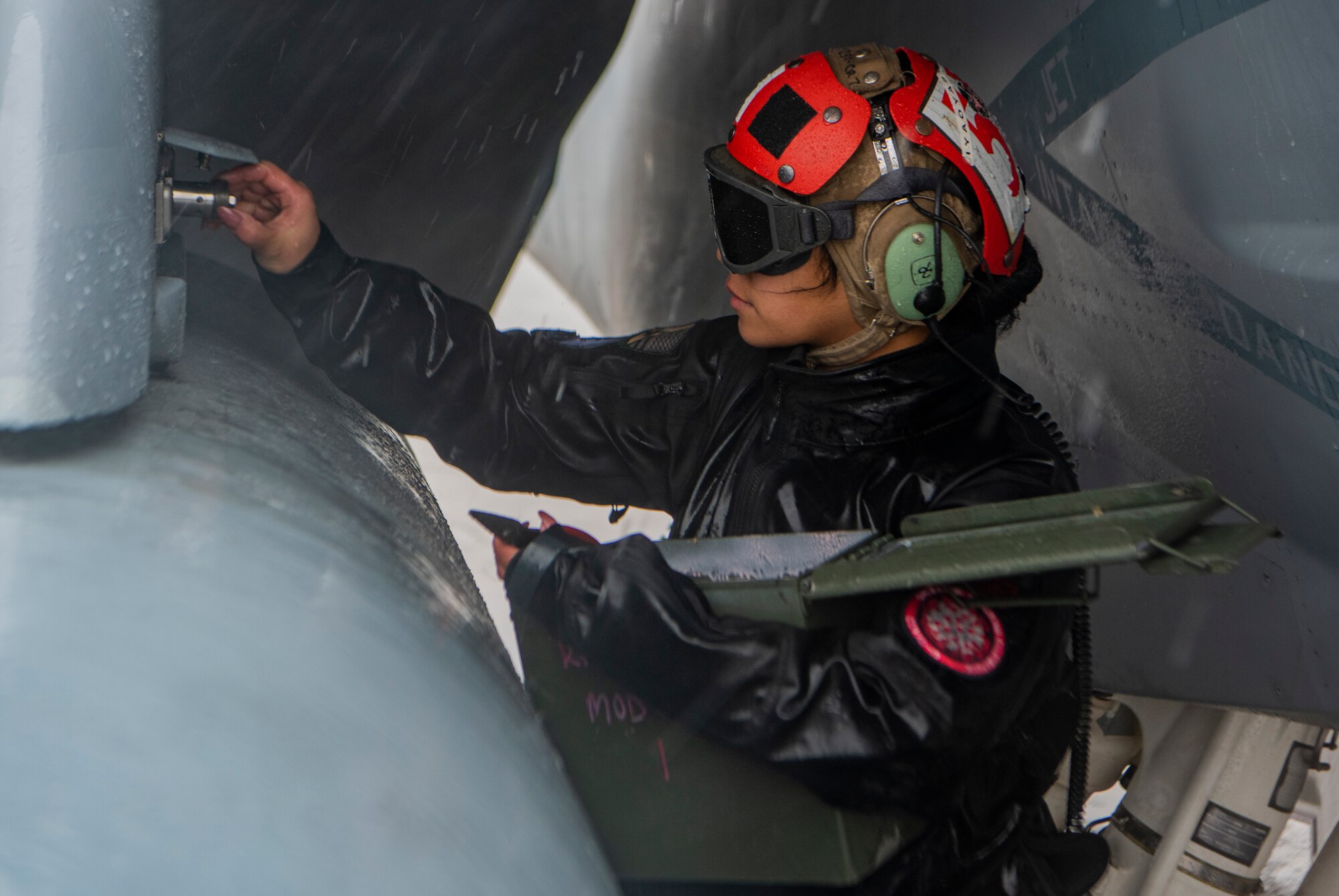 U.S. Navy Airman works on aircraft.