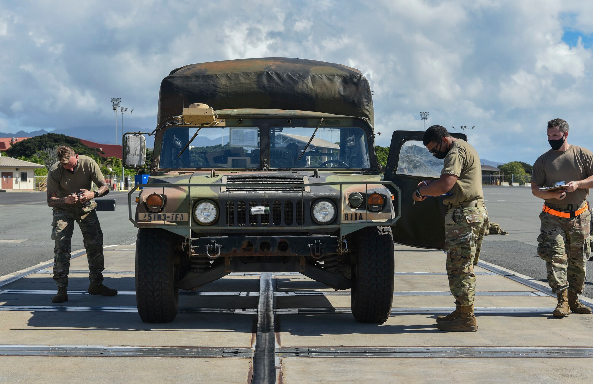 U.S. Air Force Staff Sgts. James Jackson, William McAtee, and Douglas Moyer, 735th Air Mobility Squadron air transportation supervisors, inspect an U.S. Army Humvee assigned to the 25th Infantry Division during Operation Bull Wings, an Emergency Deployment Readiness Exercise at Joint Base Pearl Harbor-Hickam, Jan. 21, 2021. The EDRE is a no-notice, rapid-deployment exercise designed to test a unit's ability to alert, marshal, and deploy forces and equipment to an emergency disaster or for contingency operations. (U.S. Air Force photo by Tech. Sgt. Anthony Nelson Jr.)