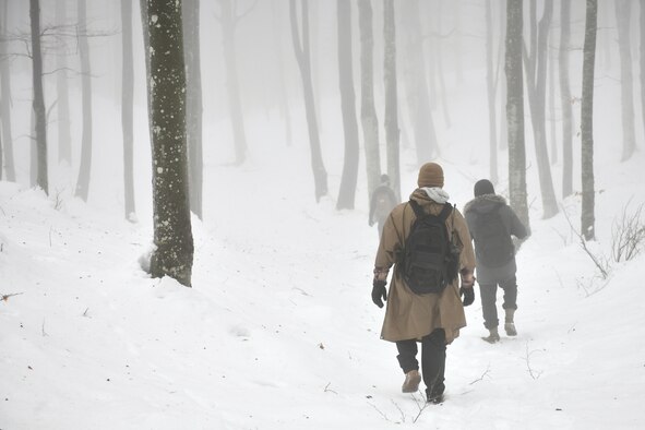 U.S. Air Force Airman 1st Class Jae Han, 31st Munitions Squadron precision guided missiles crew member, center, walks through the snow in the mountains near Pian Cansiglio, Italy, Jan. 21, 2021. Han was part of a four-man search team tasked with locating three simulated ‘survivors’ during a combat survival training exercise. (U.S. Air Force photo by Staff Sgt. K. Tucker Owen)