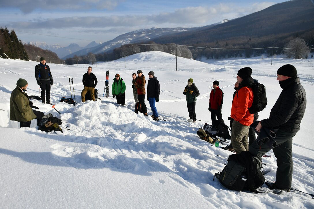 Italian air force Primo Luogotenente Stefano B., left, 15th Wing, 81st Search and Rescue Training Center instructor, speaks to U.S. Airmen assigned to the 31st Fighter Wing at Aviano Air Base, Italy, during an avalanche theory class at Piancavallo, Italy, Jan. 20, 2021. The class was attended by members of the 56th Rescue Squadron, and 510th and 555th Fighter Squadrons. (U.S. Air Force photo by Staff Sgt. K. Tucker Owen)