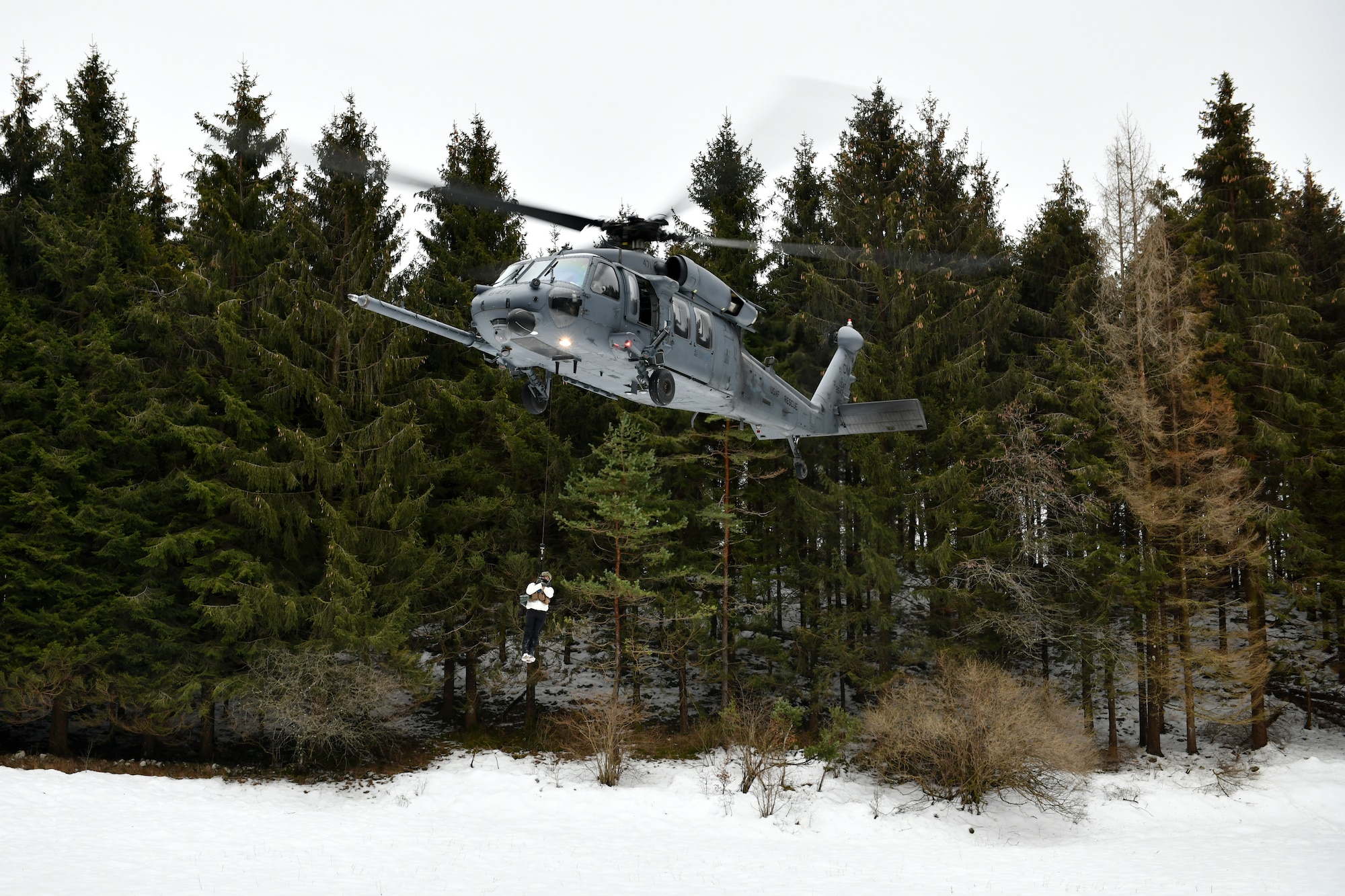 A U.S. Air Force HH-60G Pave Hawk from the 56th Rescue squadron hoists Capt. Bradley Beninati, 555th Fighter Squadron F-16 Fighting Falcon pilot, during combat survival training in the mountains near Pian Cansiglio, Italy, Jan. 21, 2021. All three ‘survivors’ made it to the designated area for recovery, where they were able to make contact with the 56th RQS for retrieval. (U.S. Air Force photo by Staff Sgt. K. Tucker Owen)