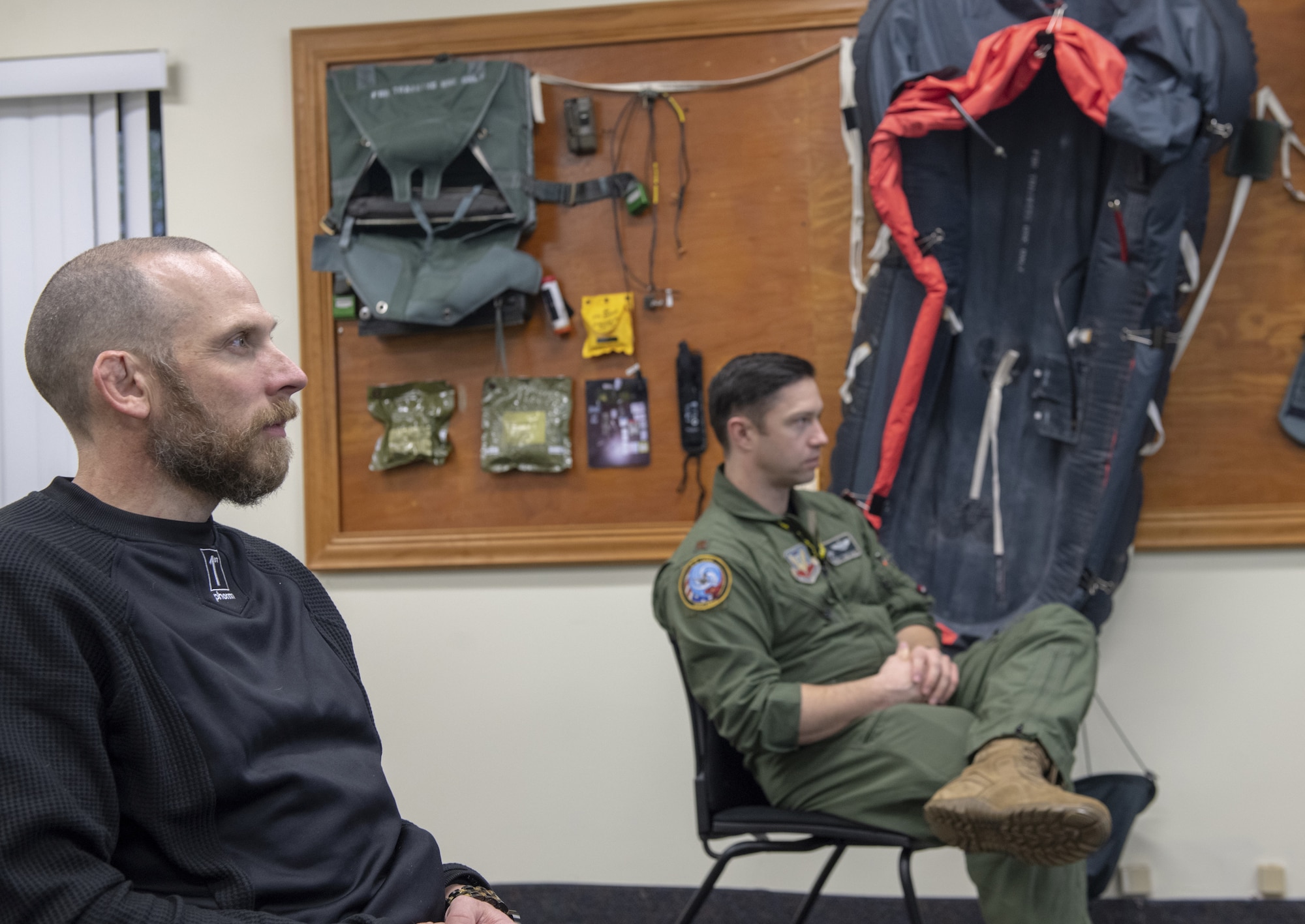 Photo of pilot and man listening to briefing.
