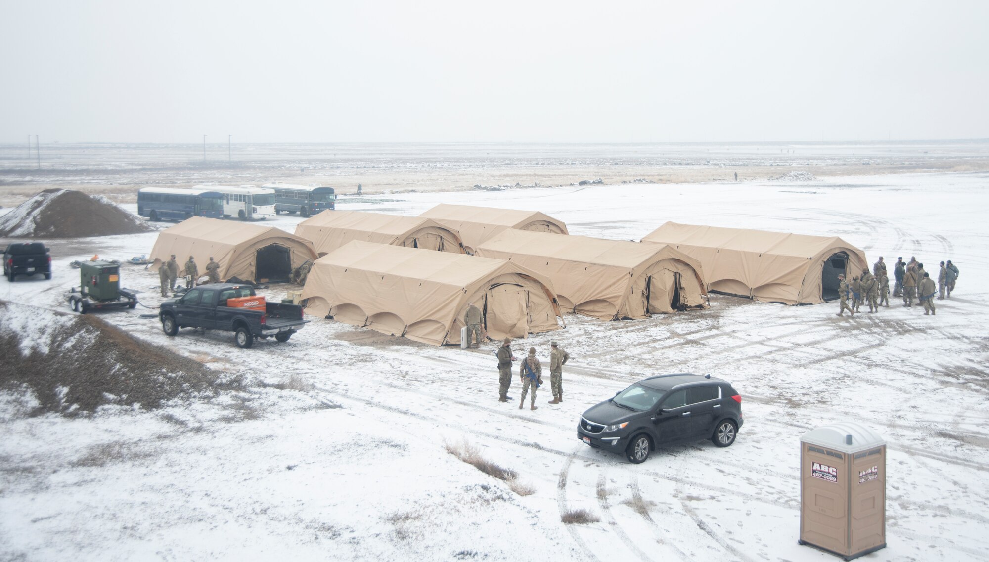 A picture of six large tents sitting on a snowy land.