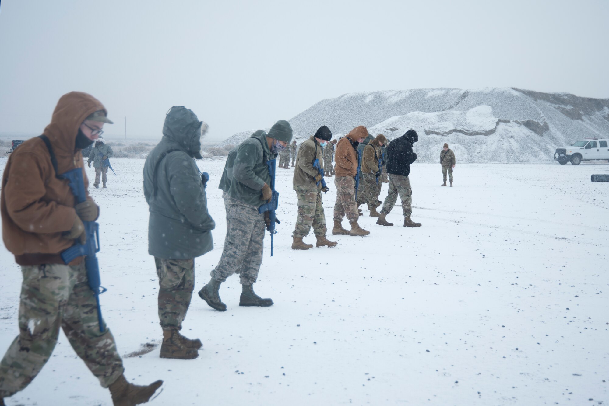 A group of Airmen walks and search for simulated unexploded ordnance.