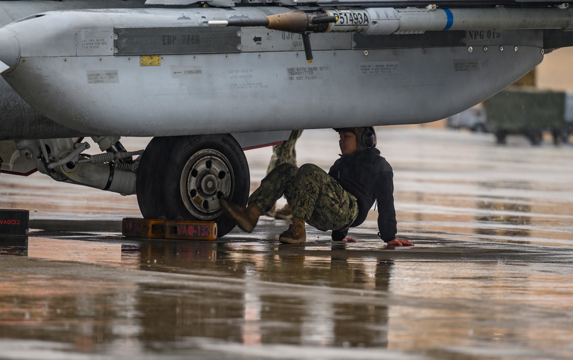 U.S. Navy airman works on aircraft.