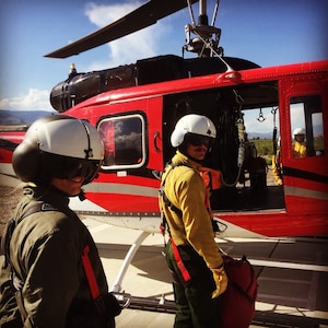 A man and woman next to a helicopter