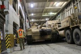 Capt. Christopher Lang, 1185th Deployment and Distribution Support Battalion, inspects the loading process aboard the Green Ridge at the Port of Shuaiba, Kuwait, Jan. 22, 2021. The equipment, bound for the United Arab Emirates, will be received by 2/1 ABCT Soldiers and is scheduled to be utilized during exercise Iron Union 14. (U.S. Army photo by Claudia LaMantia)