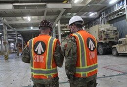 Capt. Christopher Lang, 1185th Deployment and Distribution Support Battalion, and Maj. Gregory Gemedschiew, 1185th DDSB, discuss the loading plan for 2nd Armored Brigade Combat Team, 1st Armored Division, equipment aboard the Green Ridge at the Port of Shuaiba, Kuwait, Jan. 22, 2021. The equipment, bound for the United Arab Emirates, will be received by 2/1 ABCT Soldiers and is scheduled to be utilized during exercise Iron Union 14. (U.S. Army photo by Claudia LaMantia)