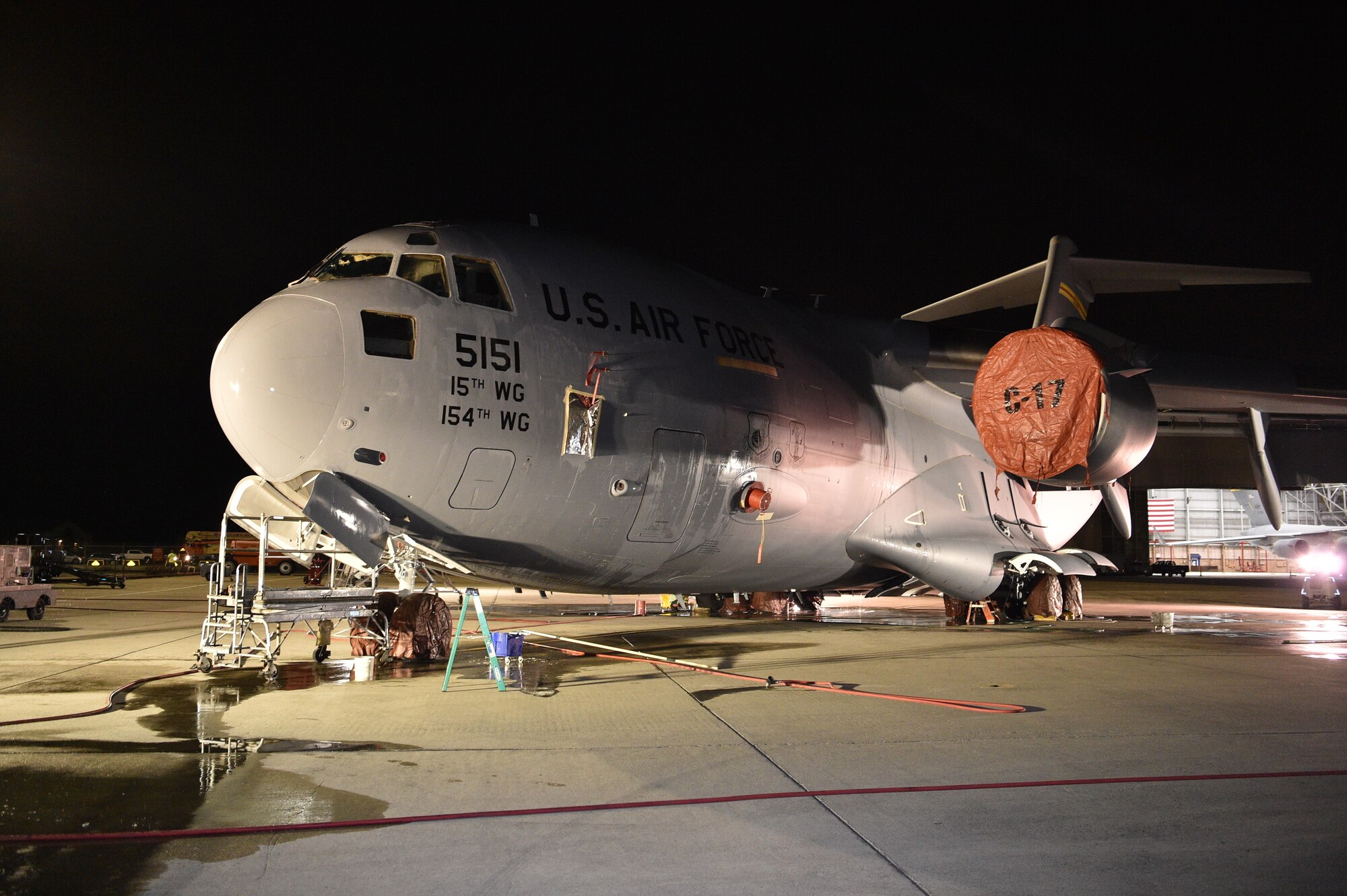 A contractor from the 15th Aircraft Maintenance Squadron washes a C-17 during a bird bath on the flightline at Joint Base Pearl Harbor-Hickam, Jan. 7, 2021. Aircraft undergo routine cleanings to prevent saltwater corrosion. (U.S. Air Force photo by Lt. Benjamin Aronson)