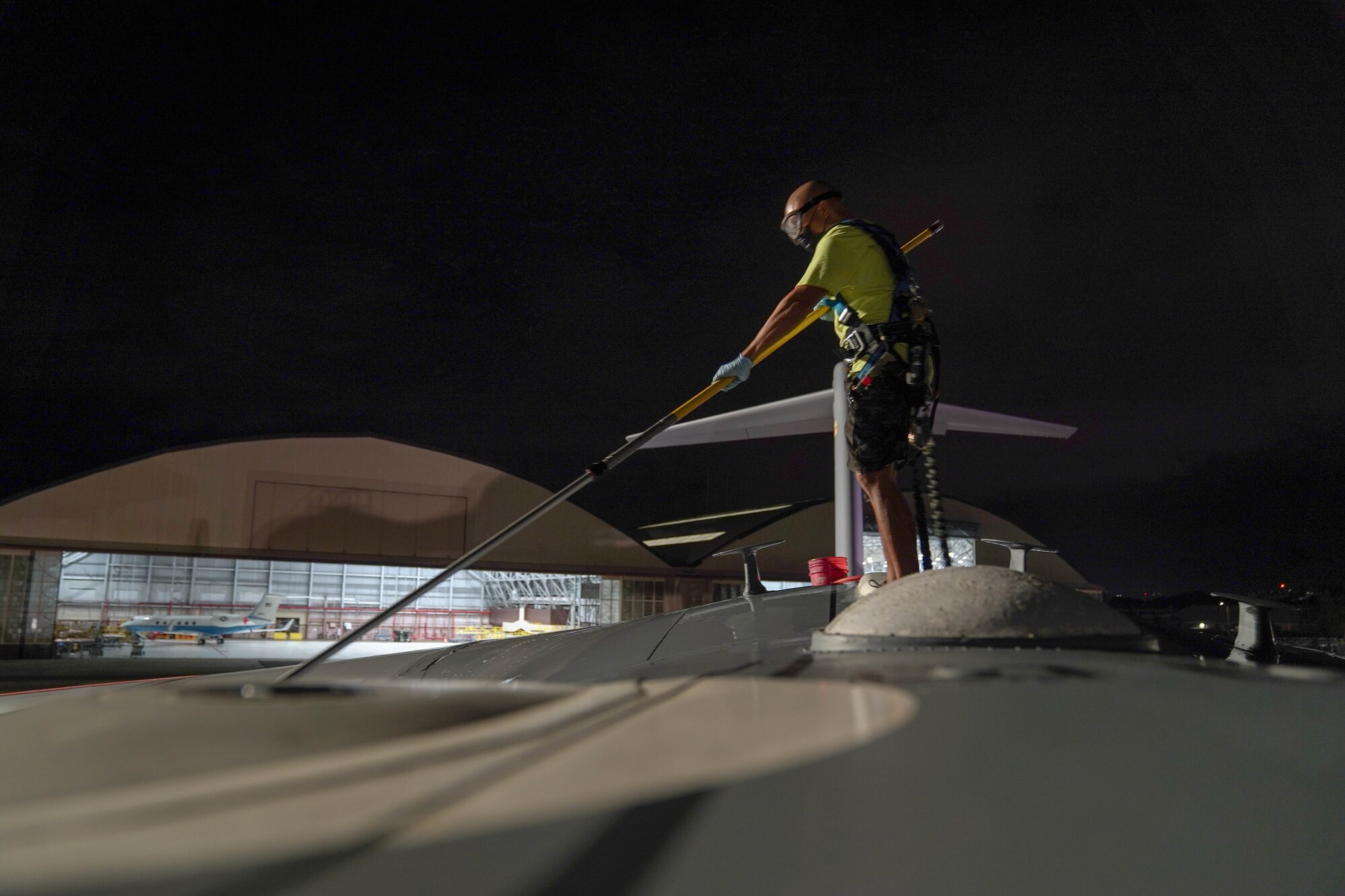 A contractor from the 15th Aircraft Maintenance Squadron washes a C-17 during a bird bath on the flightline at Joint Base Pearl Harbor-Hickam, Jan. 7, 2021. Aircraft undergo routine cleanings to prevent saltwater corrosion. (U.S. Air Force photo by Airman 1st Class Makensie Cooper)