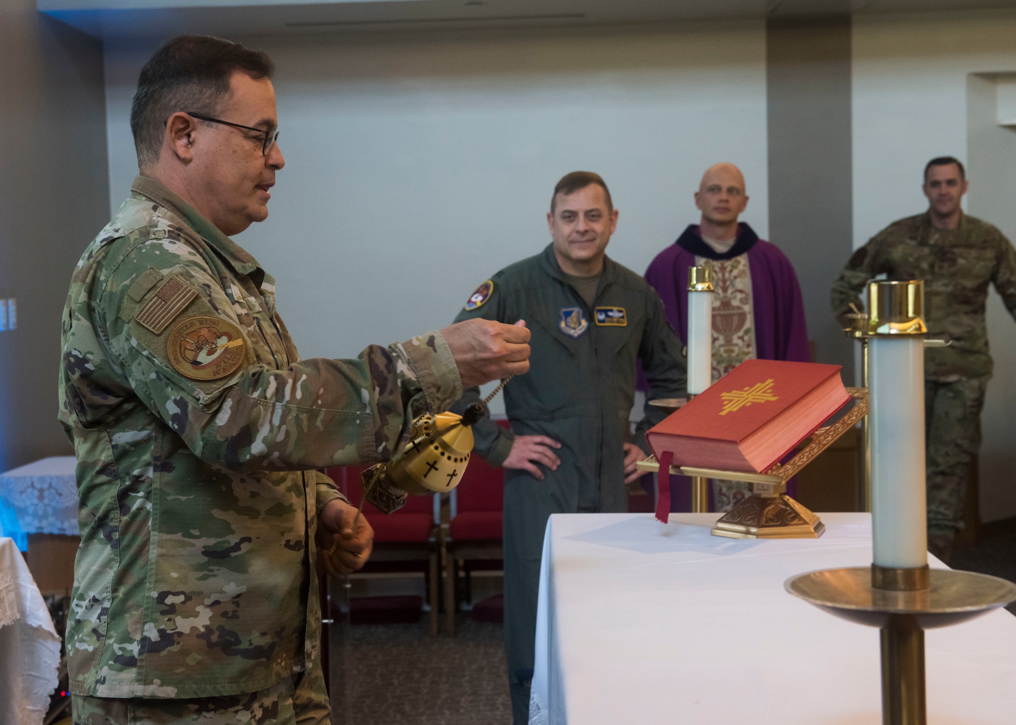 Military members burn incense at the stage of the chapel.