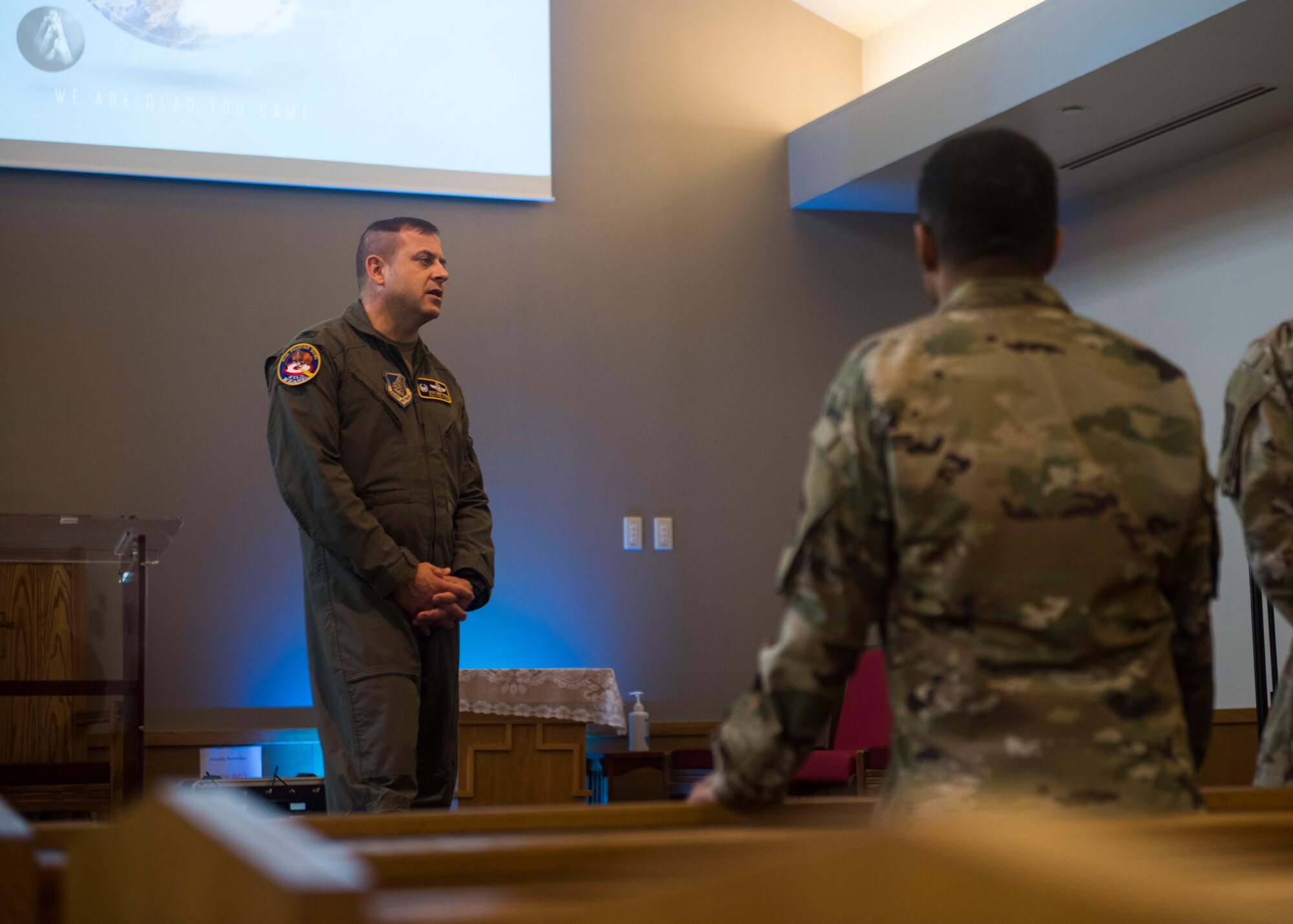 Military members talking to each in a chapel .