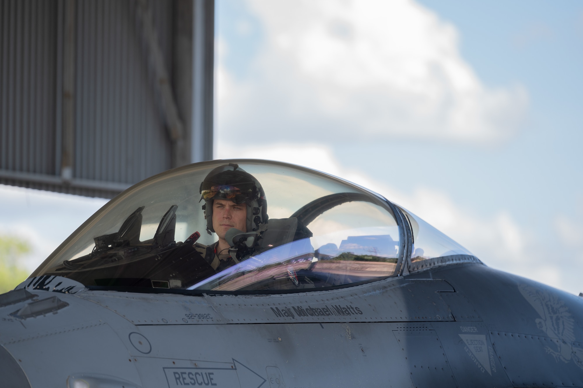 A pilot sits inside an F-16 fighter jet.