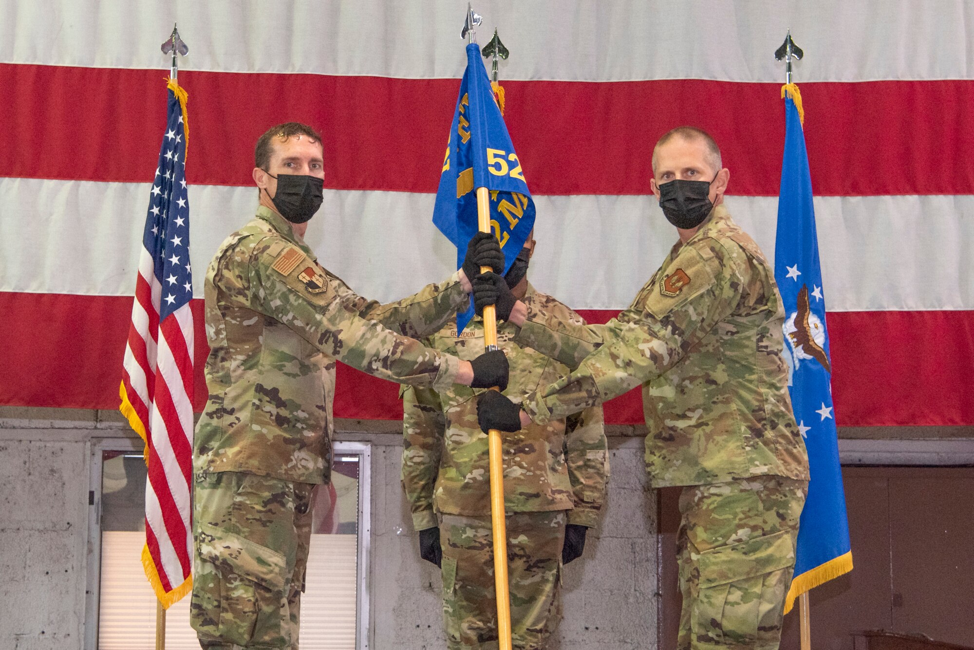 U.S. Air Force Col. David Epperson, 52nd Fighter Wing commander (left), passes the medical group guidon to U.S. Air Force Col. Peter French, the new 52nd Medical Group commander, during the 52nd MDG change of command ceremony June 30, 2021, on Spangdahlem Air Base, Germany.