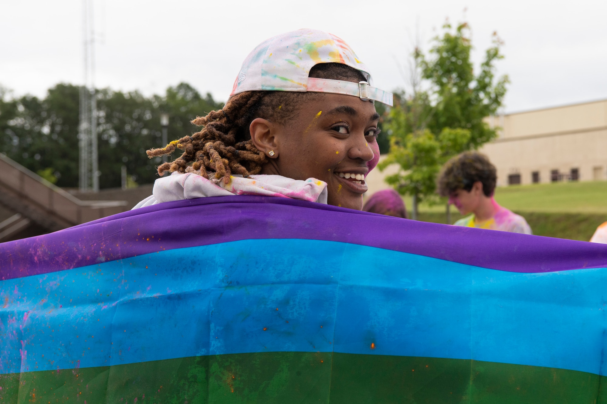 U.S. Air Force Senior Airman Robyn Pritchett, 52nd Logistic Readiness Squadron hazardous material technician, poses for a photo during a color run, June 30, 2021, on Spangdahlem Air Base, Germany. During President Joe Biden’s first day of office, he signed an Executive Order prohibiting all discrimination against lesbian, gay, bisexual, transgender, and queer  members in employment, health care, housing, lending  and education. (U.S. Air Force photo by Staff Sgt. Melody W. Howley).