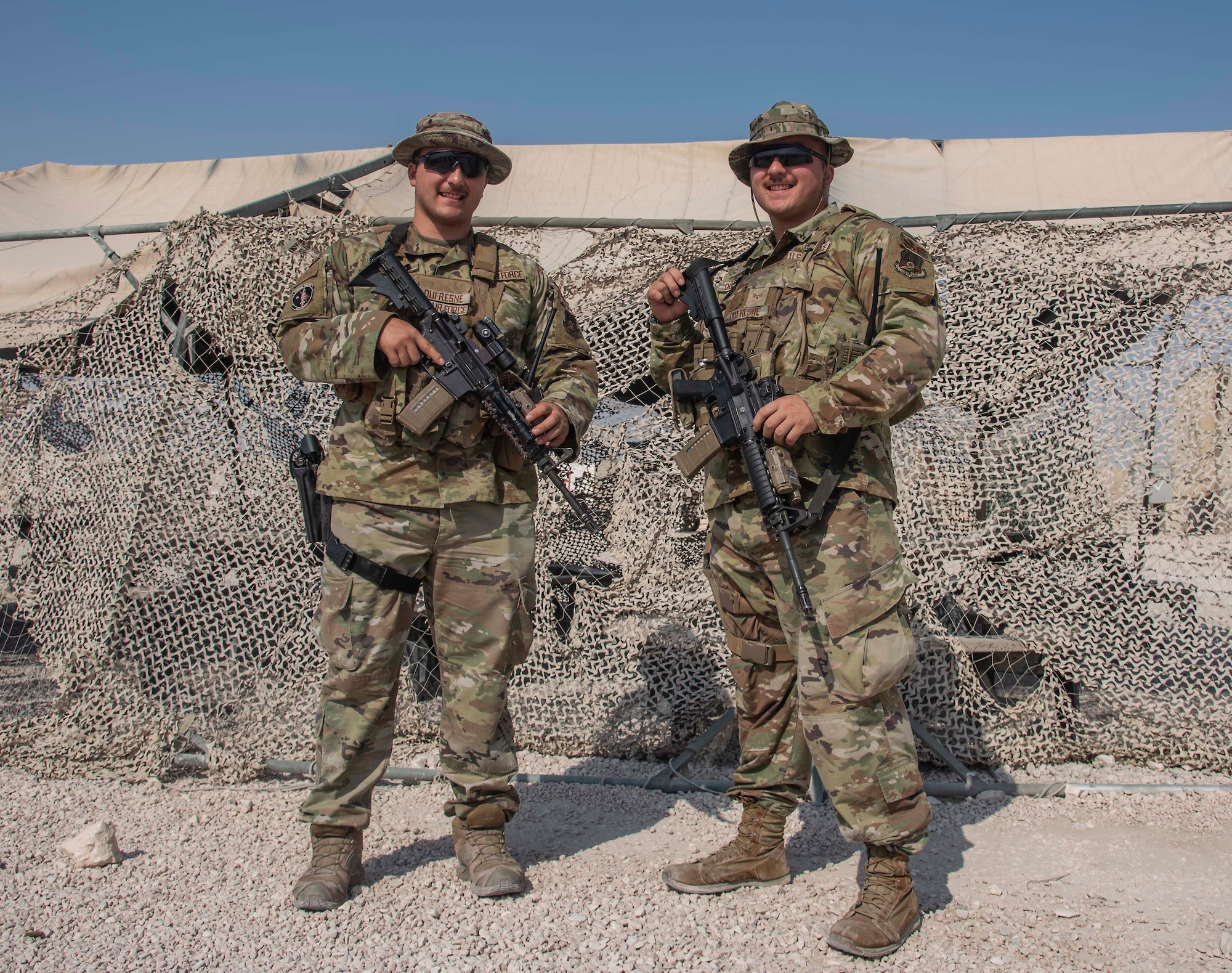 Senior Airman Christian Dufresne and Senior Airman Nicholas Dufresne, 379th Expeditionary Security Forces Squadron entry controllers, pose for a picture July 1, 2021, at Al Udeid Air Base, Qatar.