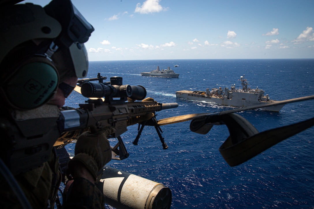 A U.S. Marine with Force Reconnaissance Platoon, 31st Marine Expeditionary Unit, sights into his M1110 semi-automatic sniper system to provide security during a Maritime Interdiction Operation training exercise aboard the USS Germantown in the Philippine Sea, June 24, 2021. The MIO consisted of Force Reconnaissance Marines fast roping on to the USS Germantown and executing a search and seizure scenario with support from the Battalion Landing Team 3/5 as the security element. The 31st MEU is operating aboard ships of the America Amphibious Ready Group in the 7th fleet area of operation to enhance interoperability with allies and partners and serve as a ready response force to defend peace and stability in the Indo-Pacific region.