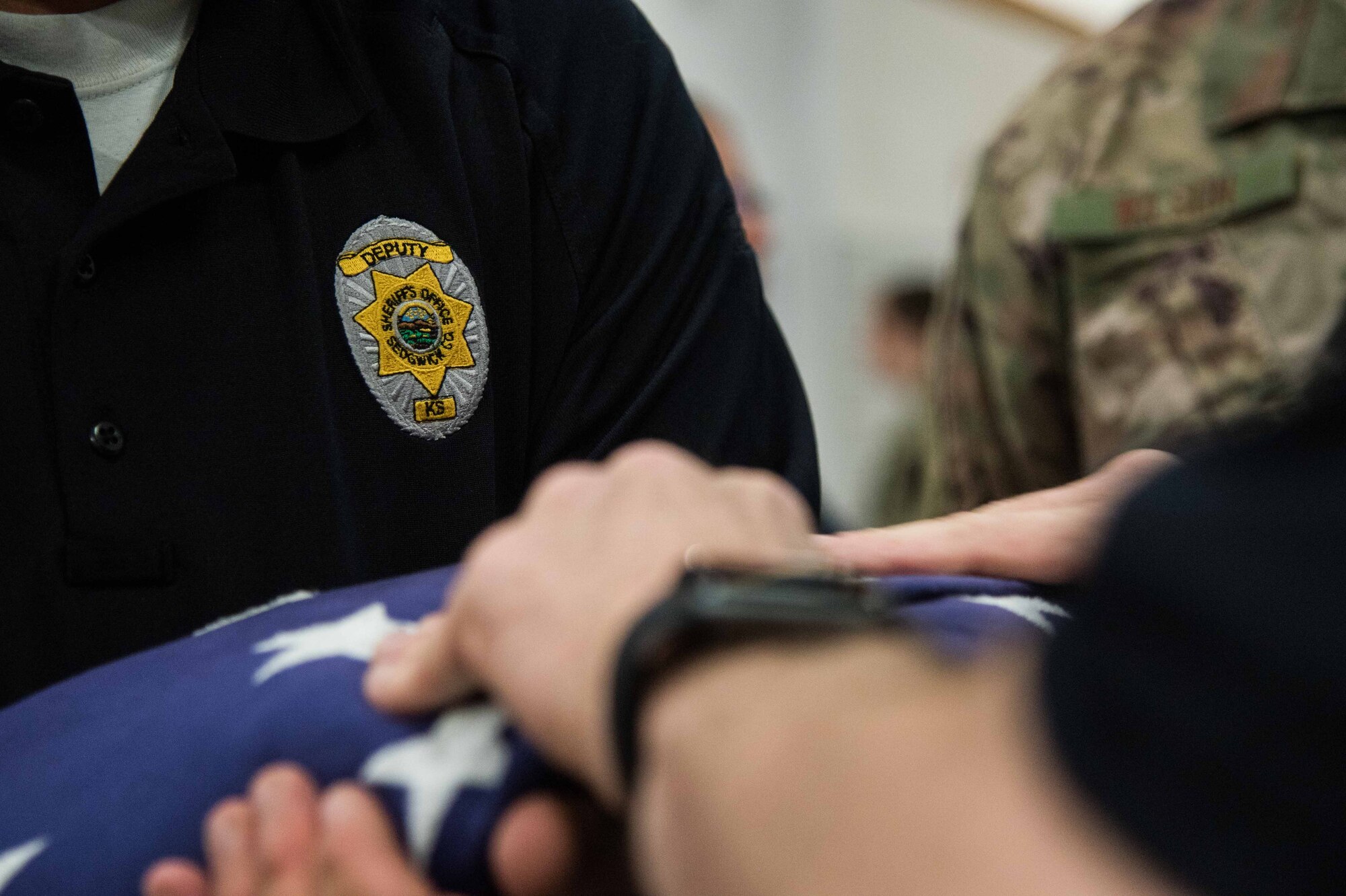 Lt. Ken Kooser, Sedgwick County honor guard commander, and Deputy Eric Dietrich, Sedgwick County honor guardsman, practice folding the flag June 30, 2021, at McConnell Air Force Base, Kansas. Members from both the Wichita City Police and Sedgwick County Honor Guards learned Air Force customs performed by honor guardsmen such as flag folding, colors presentation and rifle team training. (U.S. Air Force photo by Senior Airman Alexi Bosarge)