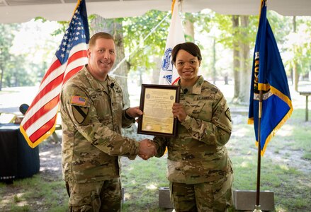 Lt. Col. Melissa Johnson receives the Product Manager Soldier Maneuver Sensor Charter from Col. Copeland.