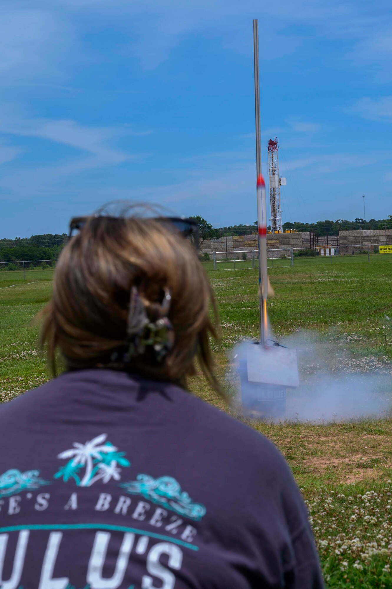 Photo of a model rocket launching as student watches.
