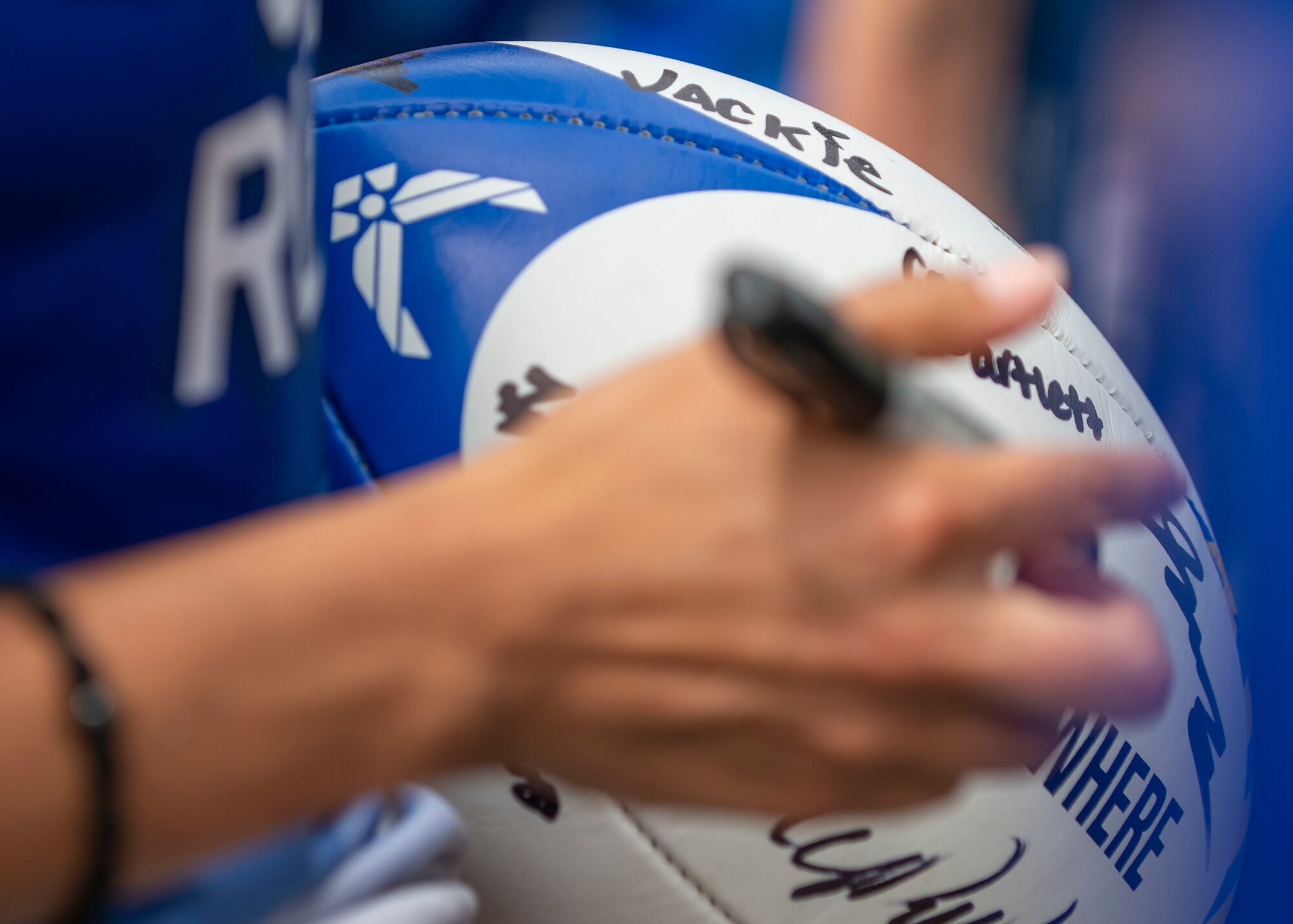 Members of the United States Air Force women’s rugby team sign a ball at the Annual Armed Forces Women’s Rugby Championship in Wilmington, North Carolina, June 26, 2021.