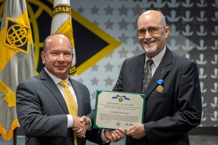 Barry W. Hoffman, U.S. Army Financial Management Command executive director, presents G. Eric Reid, a recently retired USAFMCOM Military Pay Operations director, with an Army Distinguished Civilian Service Medal during a special ceremony at the Maj. Gen. Emmett J. Bean Federal Center in Indianapolis May 26, 2021. The medal is the highest award given by the Secretary of the Army to Army civilian employees. (U.S. Army photo by Mark R. W. Orders-Woempner)