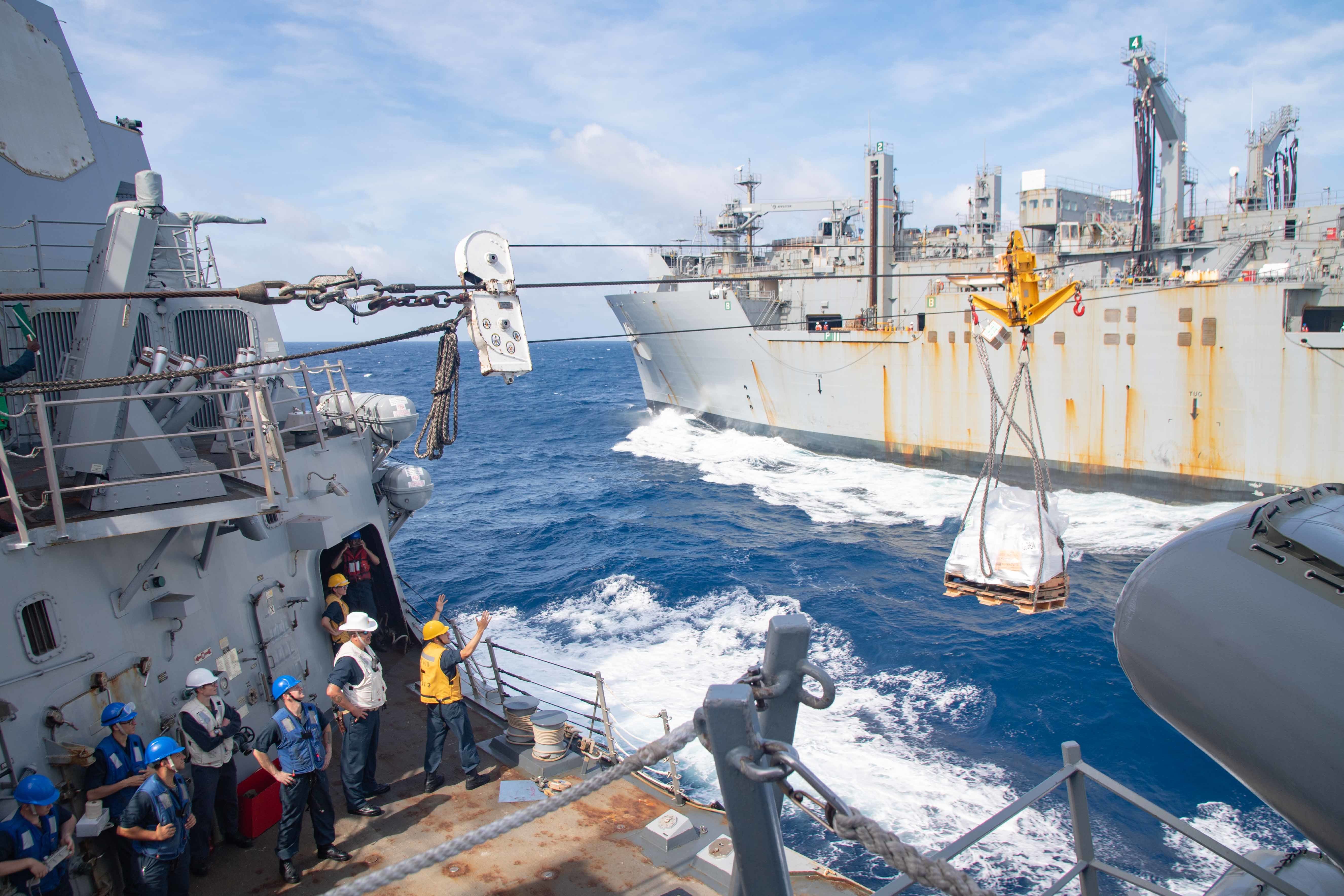 Sailors receive supplies aboard the Arleigh Burke-class guided-missile destroyer USS Kidd (DDG 100) from the fleet replenishment oiler USNS Charles Drew (T-AO 10) during a replenishment-at-sea.